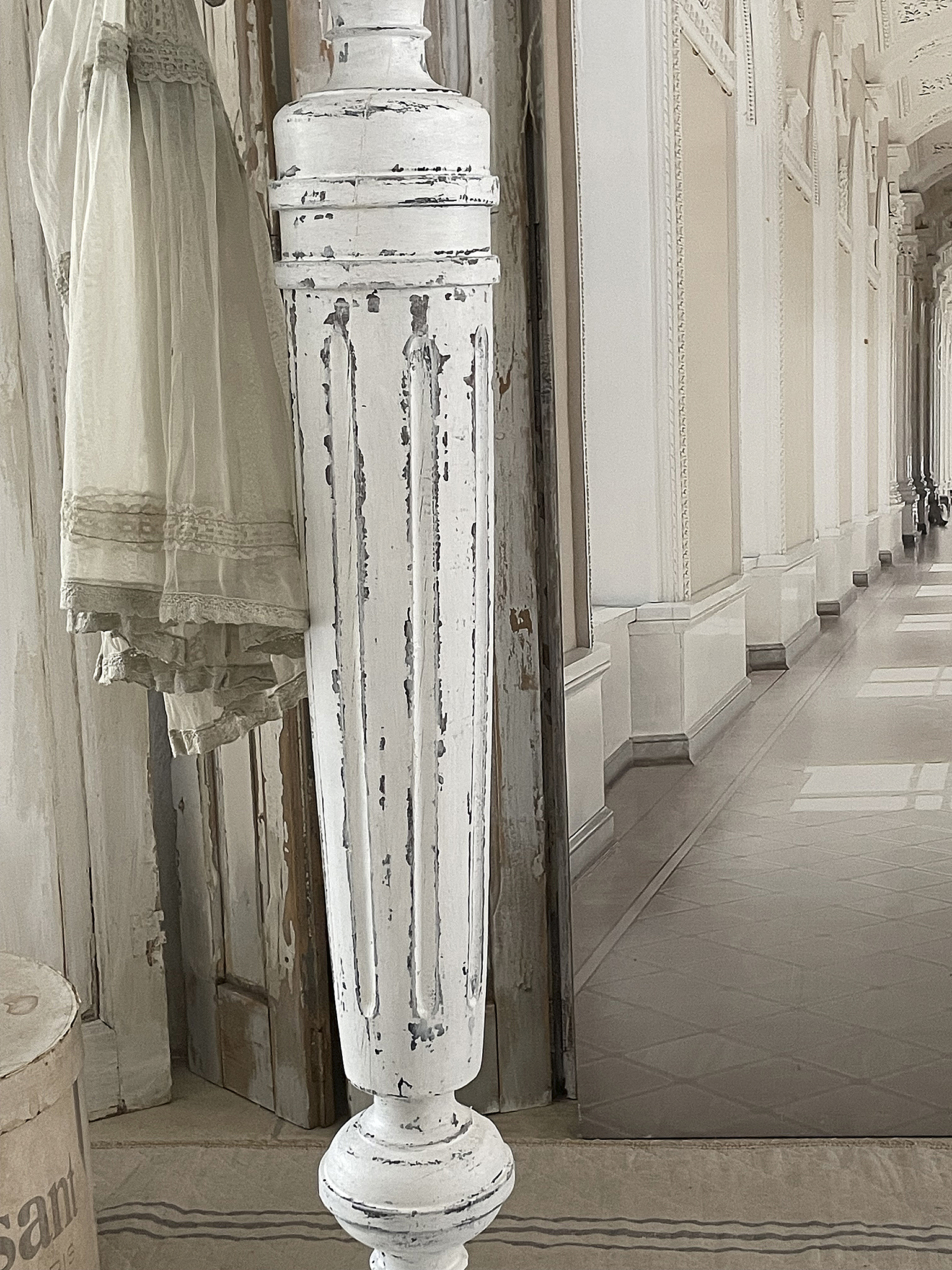 Vintage weißen Kleiderständer in eleganter Umgebung Ein dekorativer weißer Kleiderständer vor einem hellen Flur mit gefliesten Boden und historischen Elementen