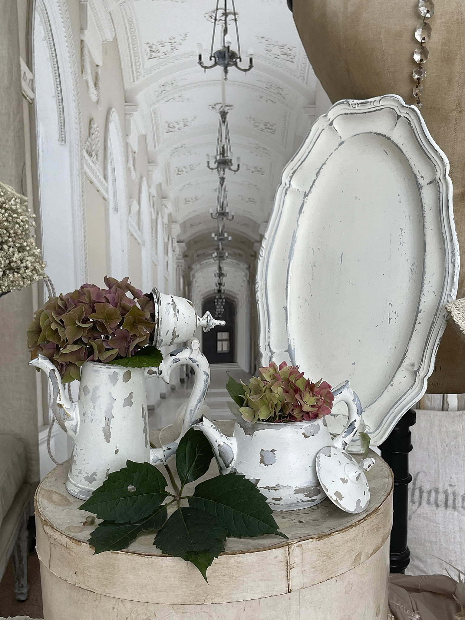 Antike Teekanne mit Hortensien und Dekoration Dekorativer Tisch mit antiker Teekanne, Blumenausgestaltung und eleganten Details