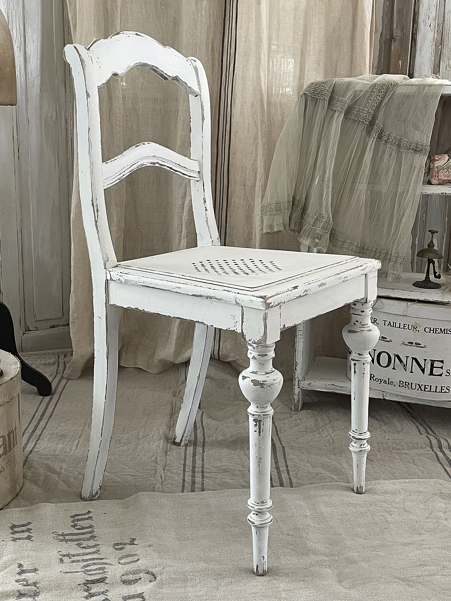 Vintage weißer Holzstuhl im Shabby-Chic-Stil Schöner vintage Holzstuhl mit weißer Farbe und Shabby-Chic-Optik auf einem neutralen Untergrund