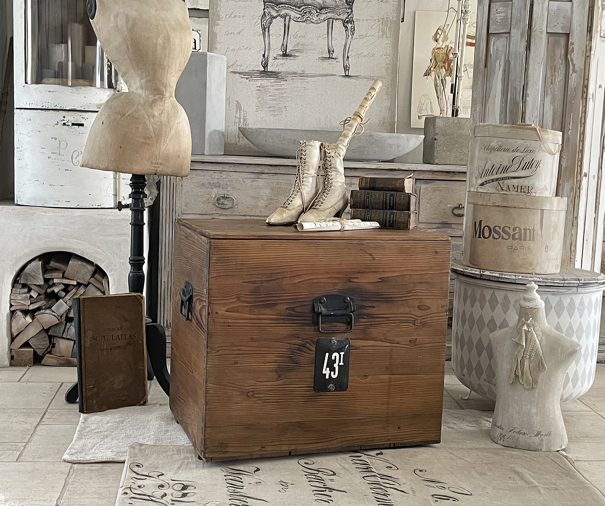 Dekorativer Holzkasten mit Vintage-Accessoires Holzkasten mit Schuhen und Büchern in einem stilvollen Raum
