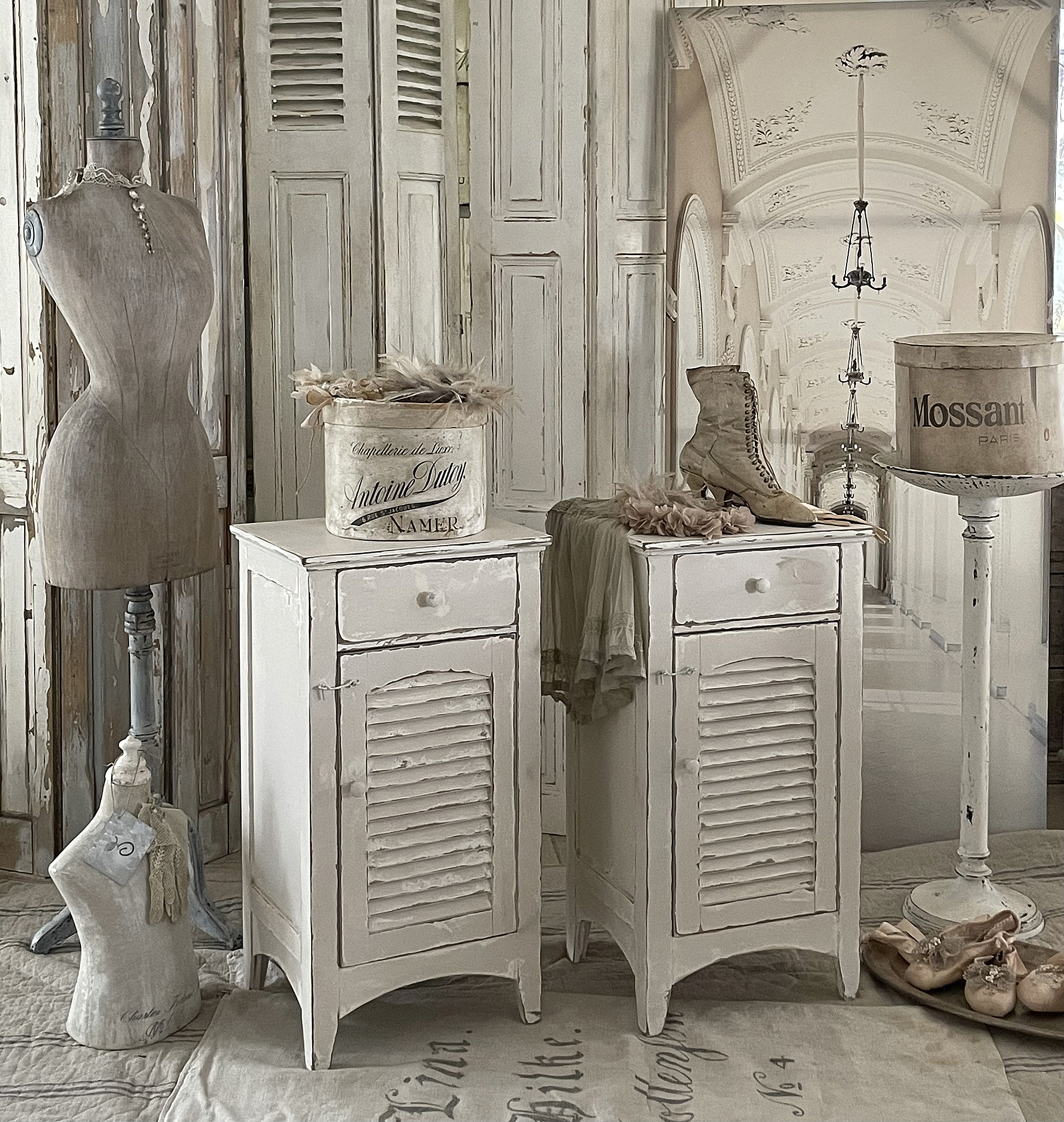 Charmante Vintage-Kommode im Landhausstil für stilvolle Interieurs Zwei weiße Kommoden im Vintage-Look mit Dekoration und einer Schneiderpuppe im Hintergrund