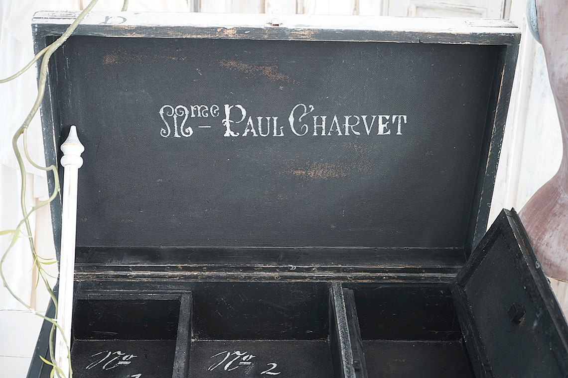 Detailansicht einer antiken Kiste mit der Innenschrift 'Sire Paul Charvet' und mehreren Fächern