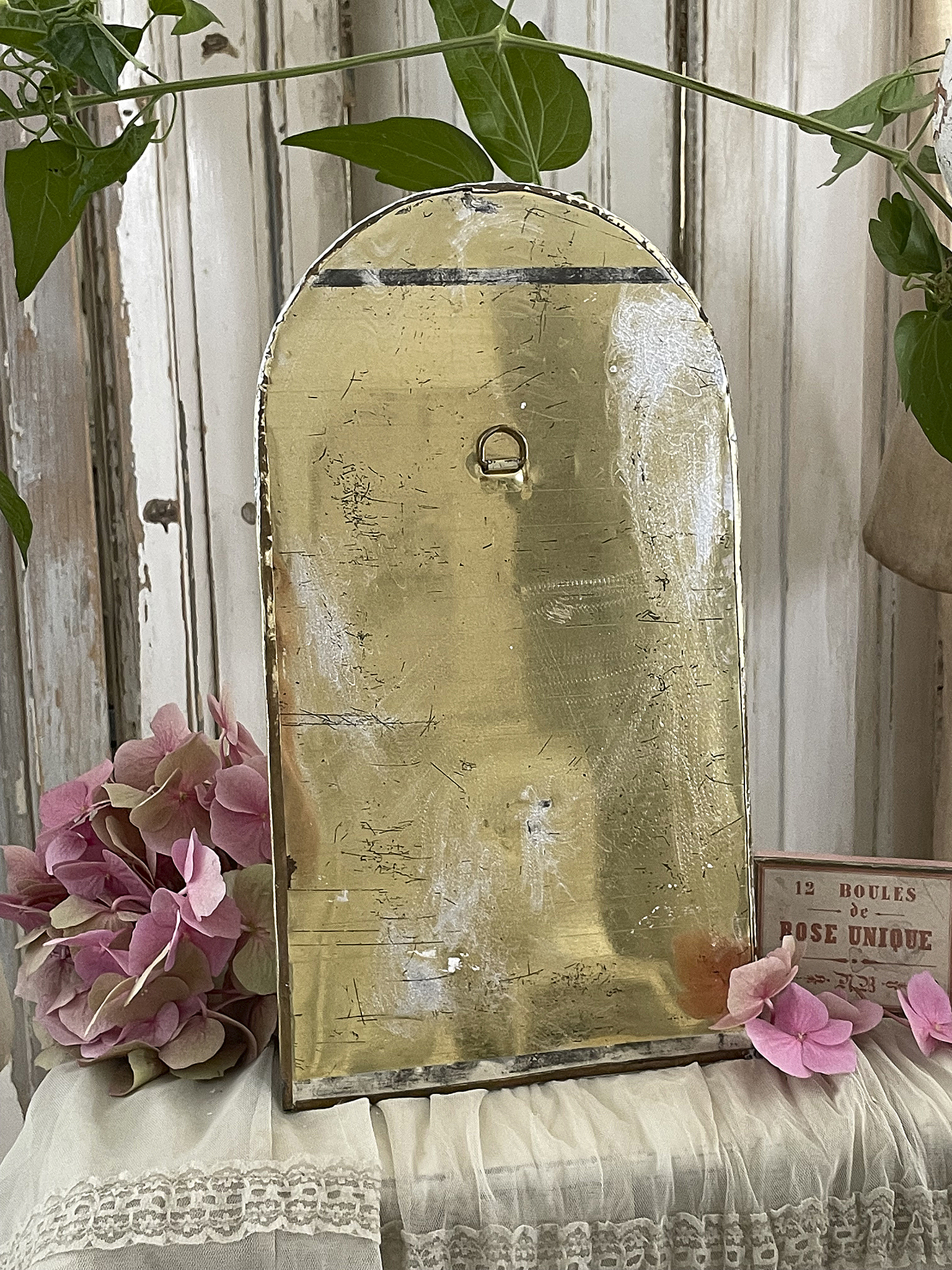 Dekorative goldene Wanddekoration mit Anhänger und einer Vielzahl von Blumen in Rosa und Lila