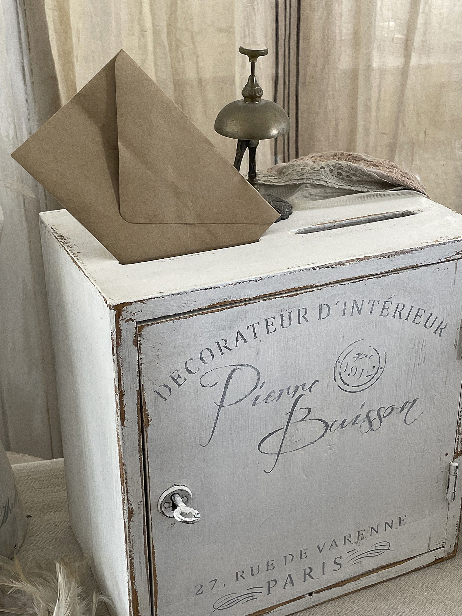 Vintage Postkasten mit Briefumschlag und antiker Klingel Antiker Postkasten mit einem braunen Briefumschlag und einer schönen Tischglocke.