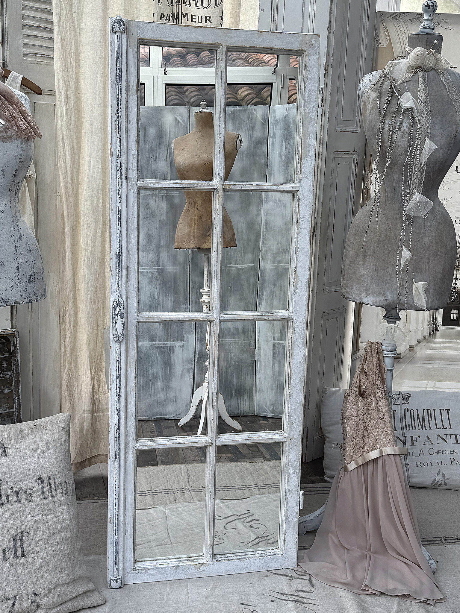 Vintage Spiegel mit Schaufensterpuppen und Kleidern Ein nostalgischer Spiegel mit Schaufensterpuppen und einem eleganten Kleid in einem stilvollen Raum