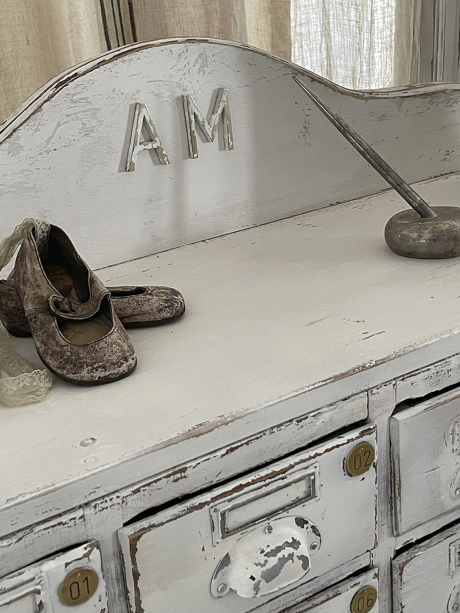 Antike Kommode mit babytauglichen Schuhen und nostalgischer Dekoration