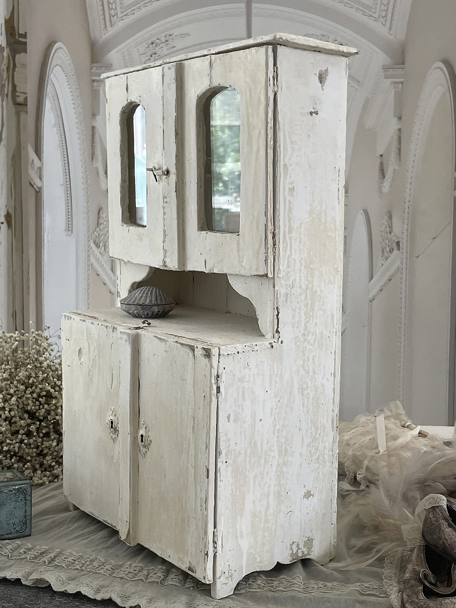 Antiker Shabby Chic Holzschrank mit Glastüren Heller antiker Holzschrank im Shabby Chic mit Glastüren und vintage Accessoires