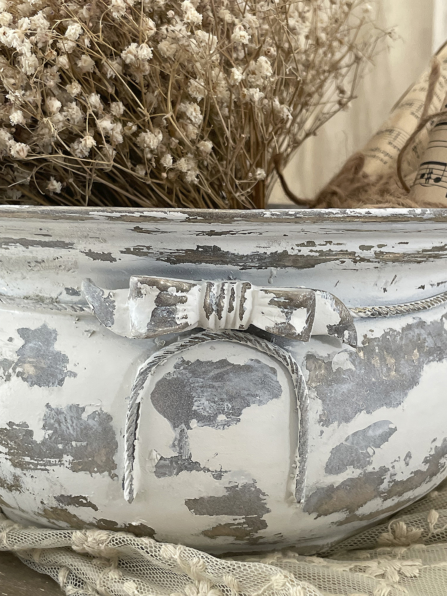 Dekorativer antiker Behälter mit Patina und Trockenblumen Antiker Behälter mit abblätternder Farbe und Trockenblumenarrangement