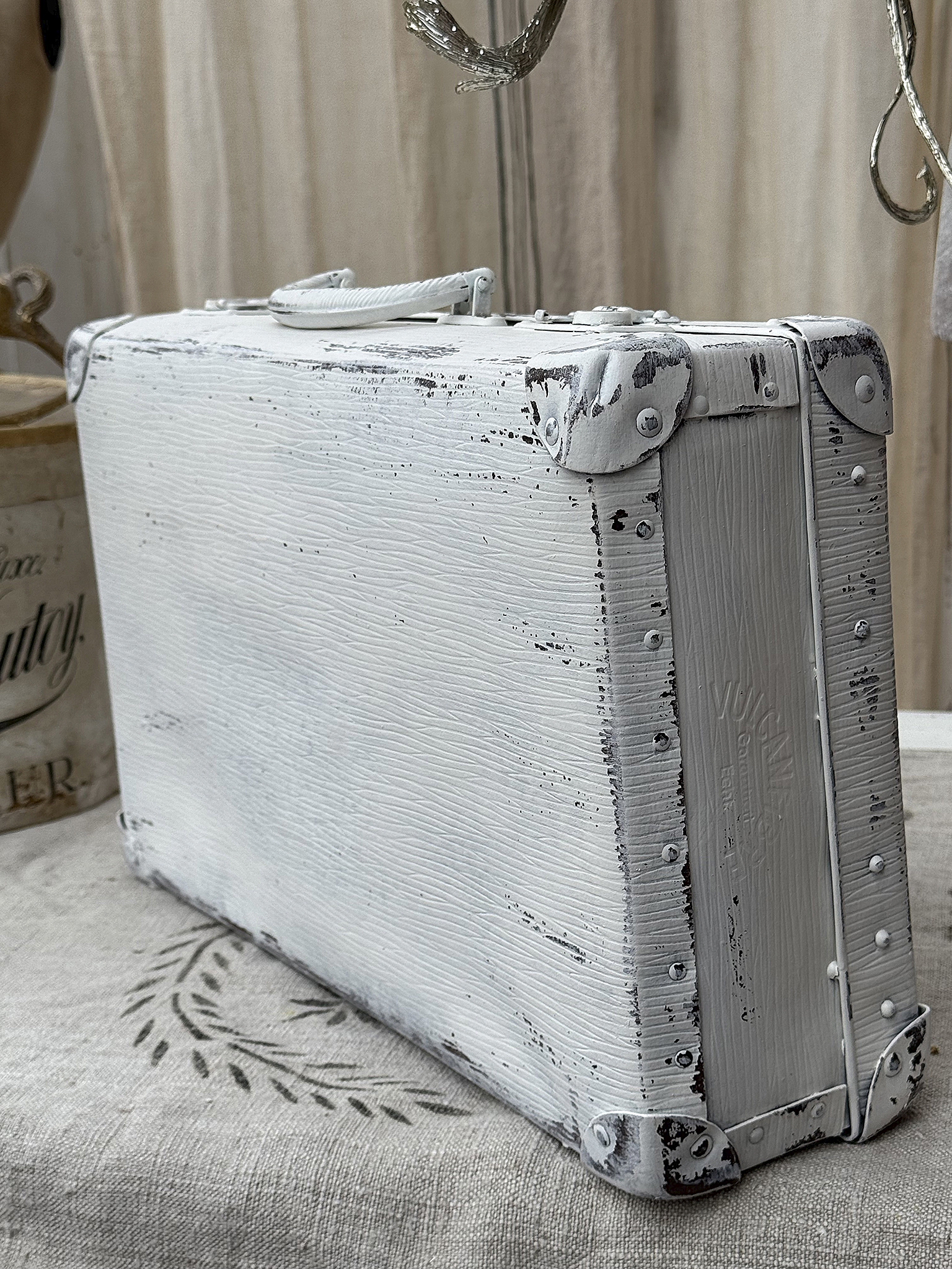 Dekorative weiße Vintage-Koffer mit patiniertem Finish Hinteransicht eines weißen Vintage-Koffers mit rustikalem Design und abgenutztem Look