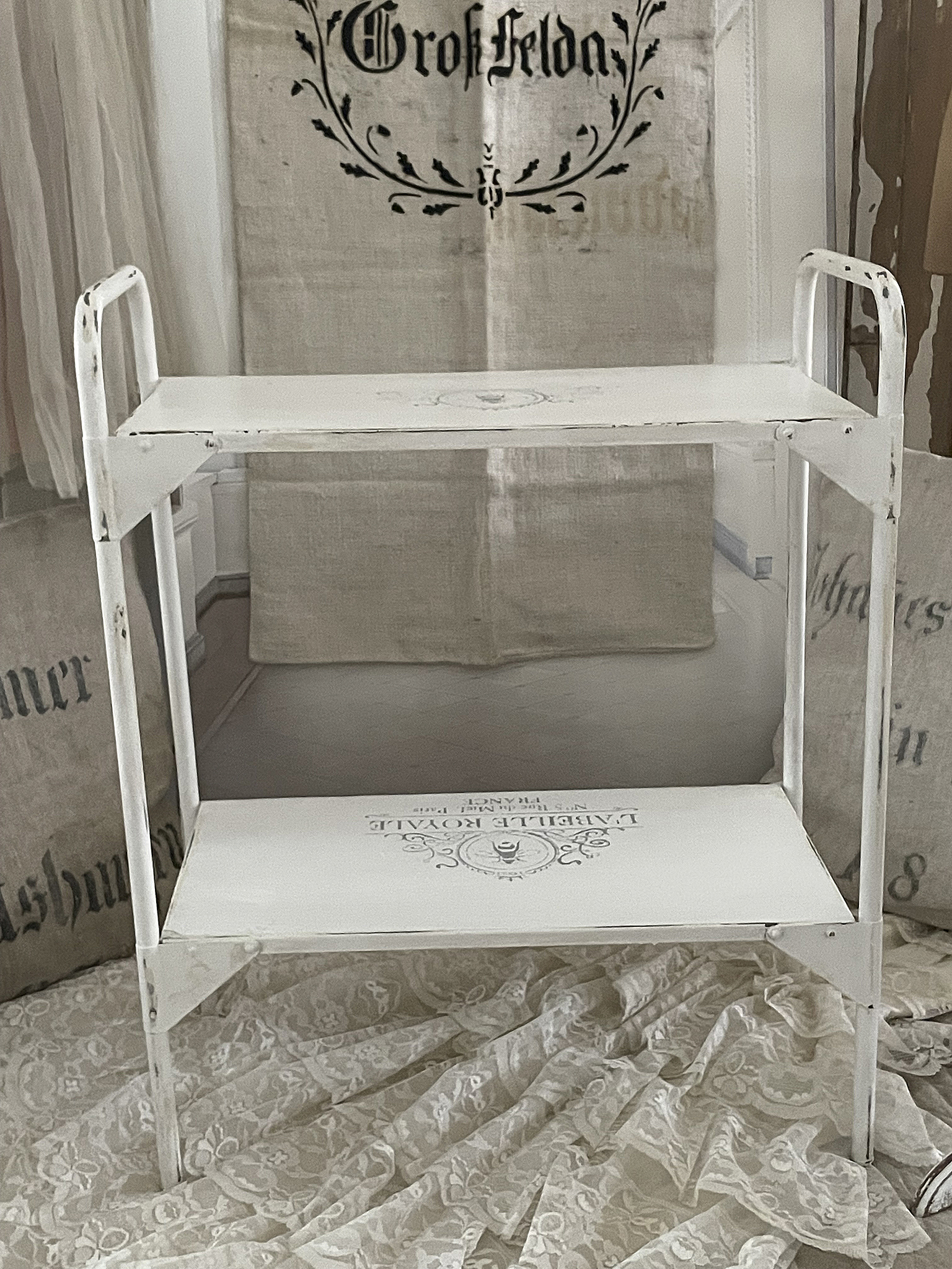 Weißer Vintage-Tisch mit zwei Ablagen, ideal für Dekoration oder als praktische Ablagefläche