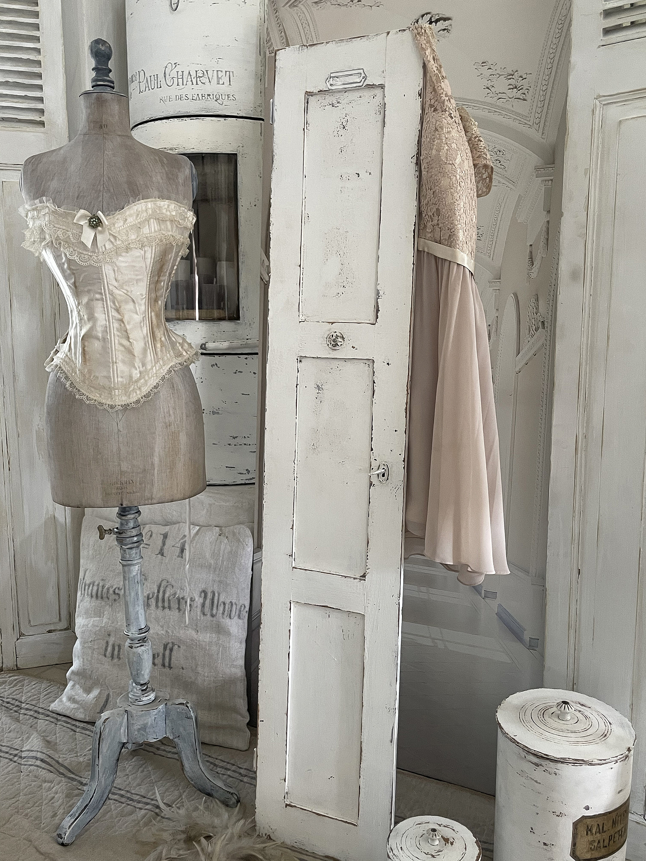 Elegantes Vintage-Setup mit Korsett und Kleid Schöner Vintage-Raum mit einem weißen Korsett auf einer Schneiderpuppe und einem elegantem Kleid im Hintergrund.
