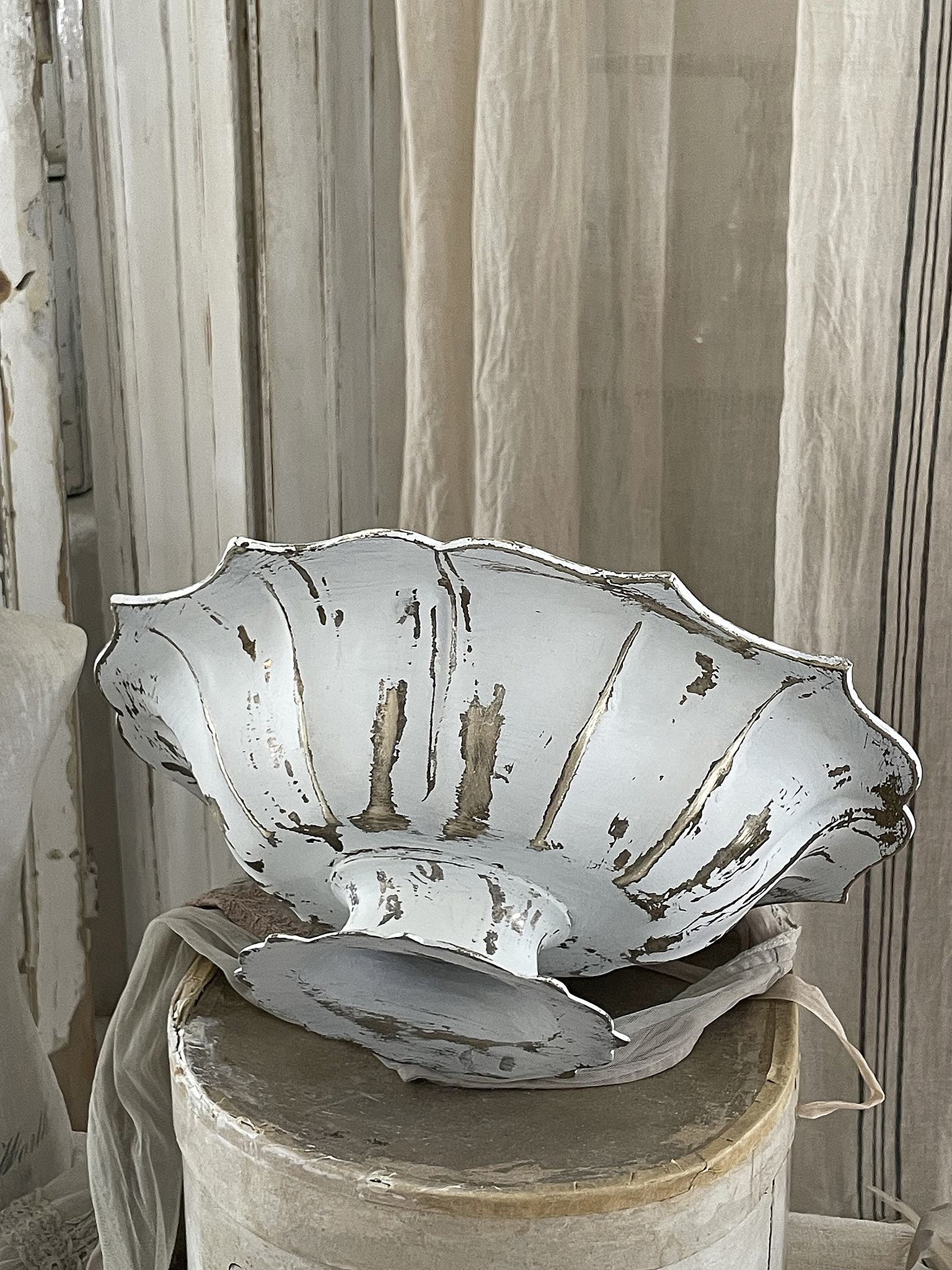 Vintage Schale aus Metall mit Shabby-Chic-Effekt Dekorative Vintage-Schale aus Metall in Silber mit gewelltem Rand und Shabby-Chic-Optik auf einem Tisch
