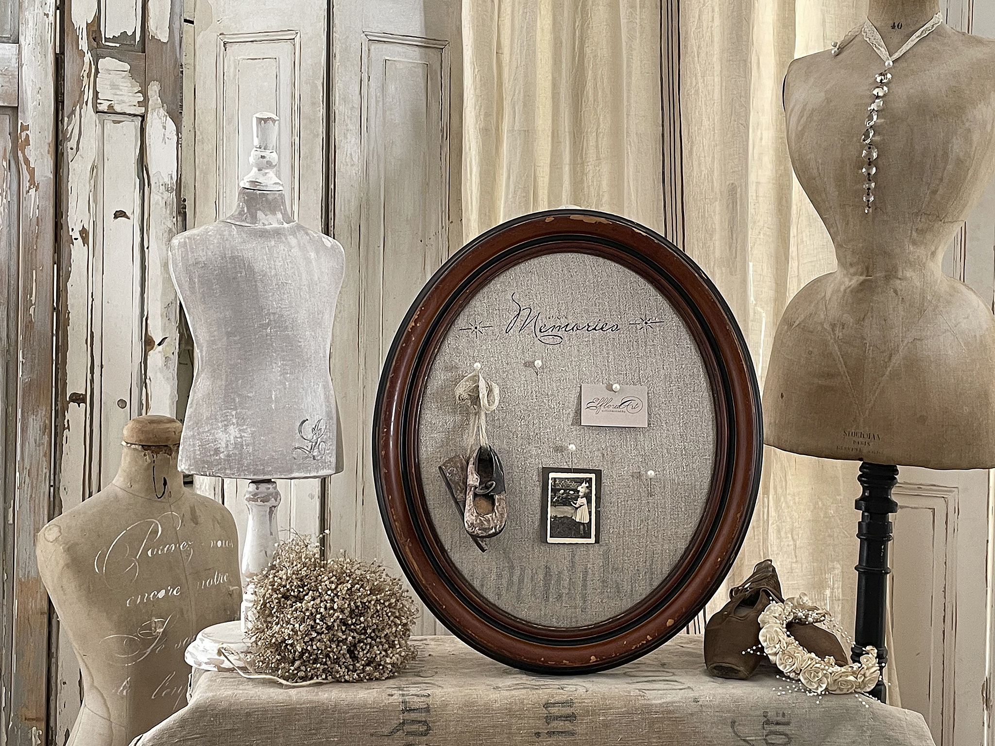 Elegante Vintage-Dekoration mit Mannequins und Erinnerungsstücken Künstlerische Anordnung von Vintage-Mannequins, einem Bilderrahmen und Dekorationsstücken
