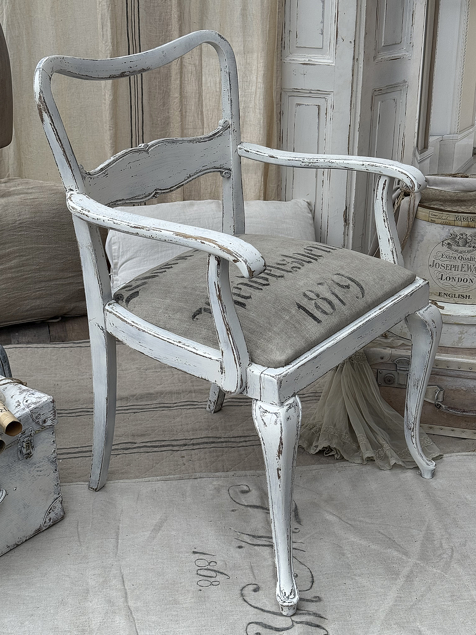 Antiker weißer Stuhl mit geschwungenen Beinen und gepolsterter Sitzfläche Antiker weißer Stuhl mit elegantem Design und Vintage-Charme
