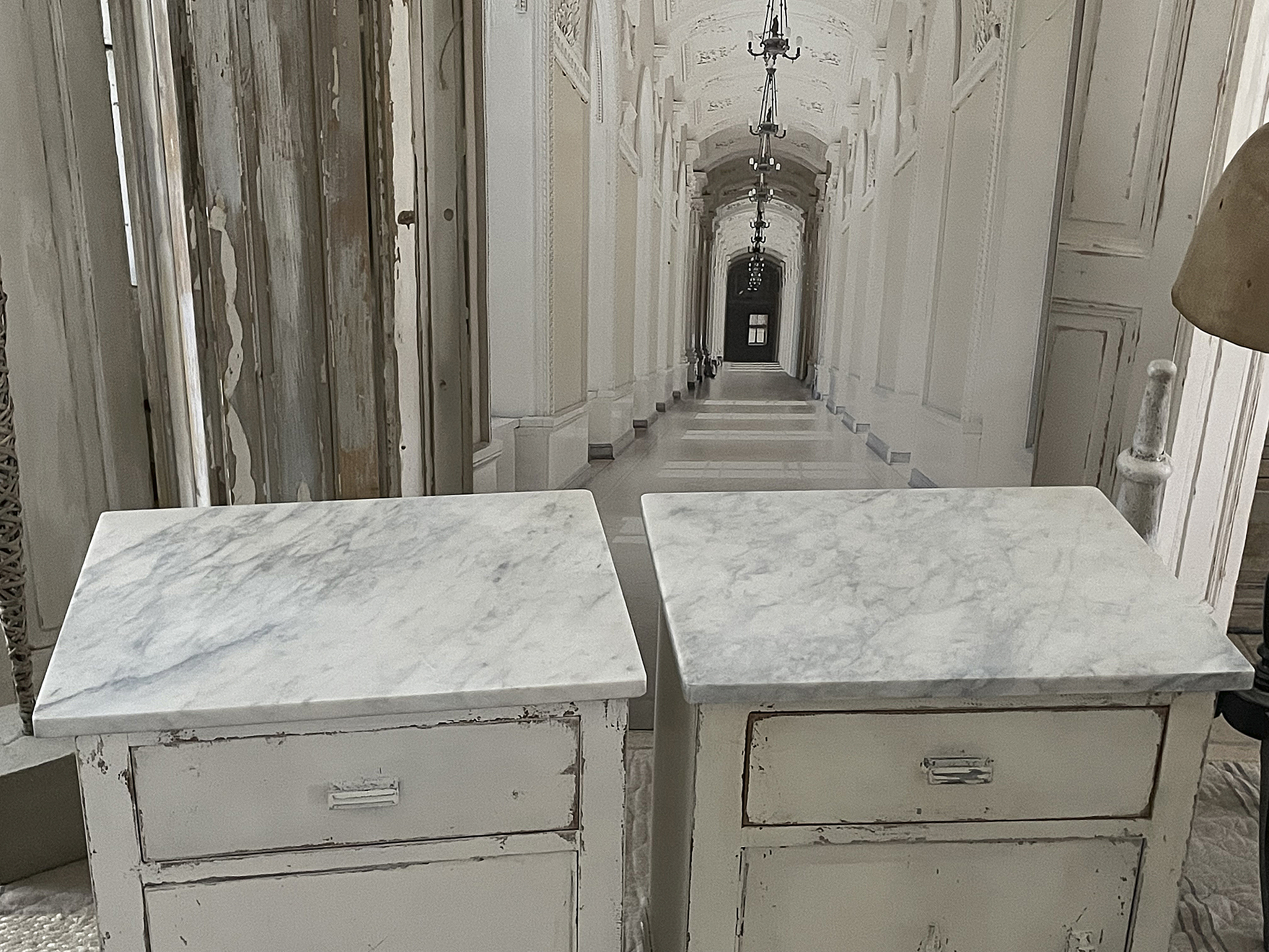 Moderne Nachttische mit Marmorplatte im eleganten Design Zwei elegante Nachttische mit Marmoroberfläche vor einem Schlossflur