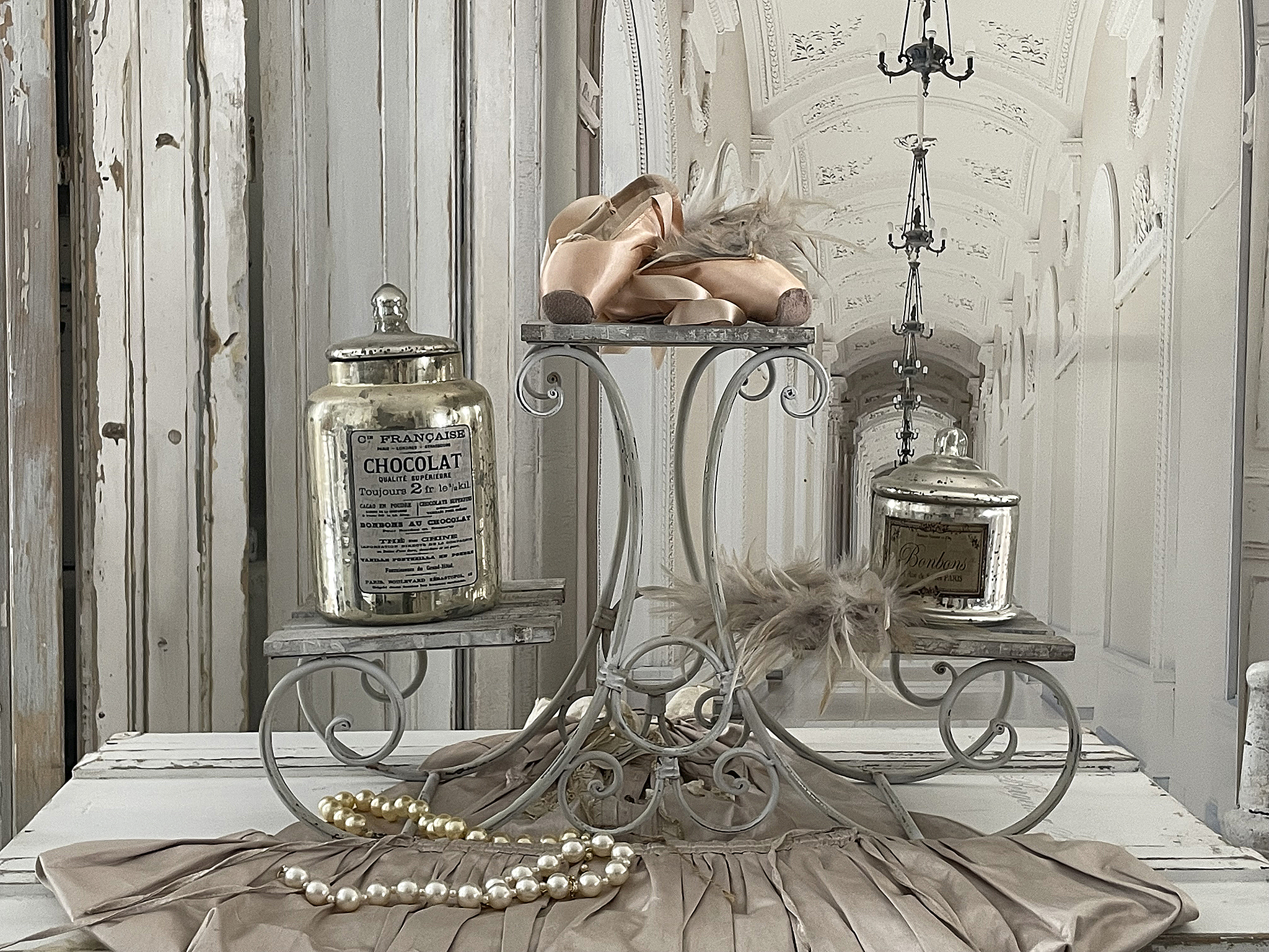 Dekorative Ausstellung mit Vintage-Accessoires und Schokolade Elegante Präsentation von Ballettschuhen, alten Schokoladendosen und Perlenschmuck auf einem stilvollen Tisch
