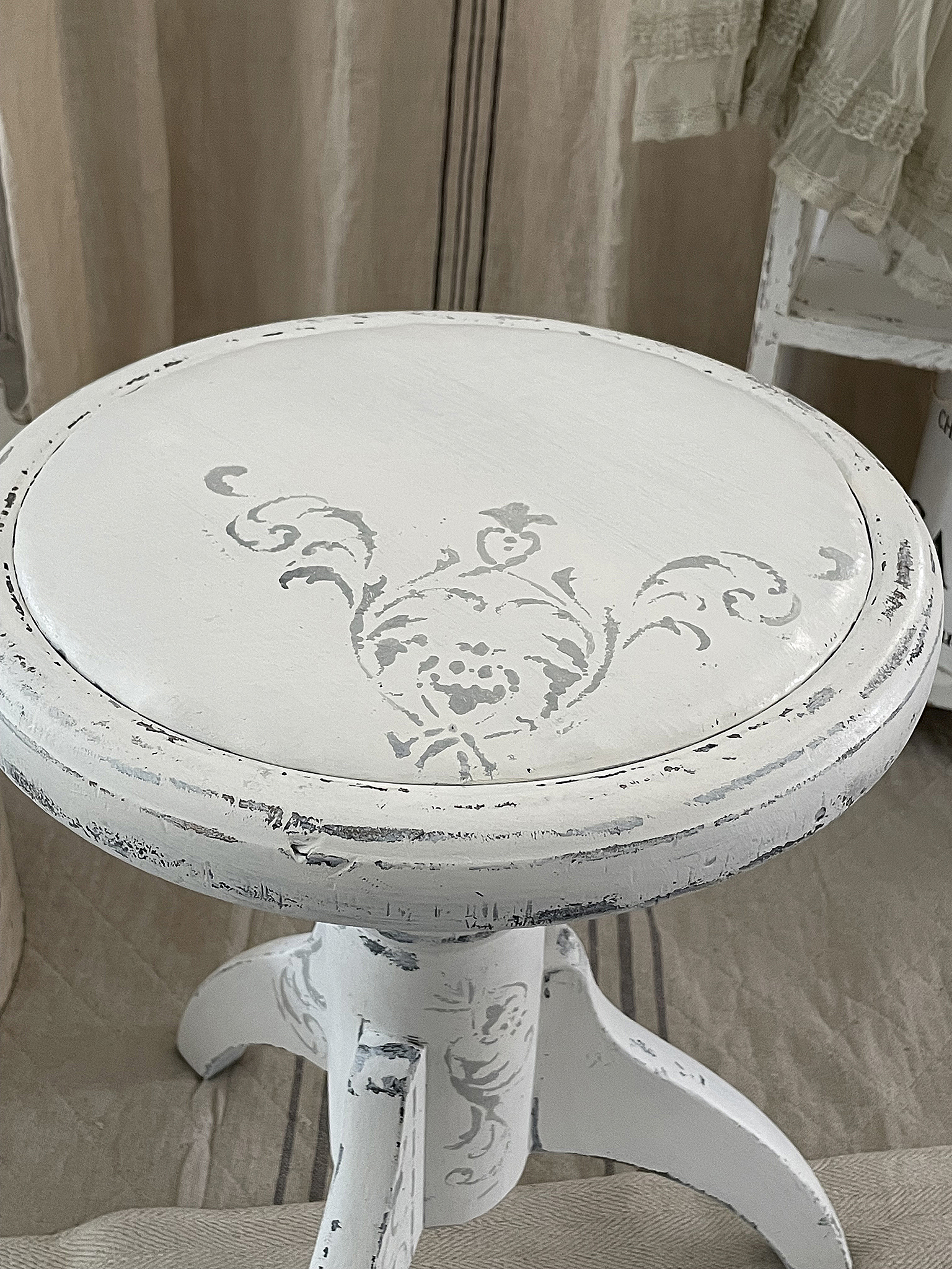 Eleganter, weißer Hocker mit floralen Motiven Weißer Hocker mit dekorativen Verzierungen auf der Sitzfläche