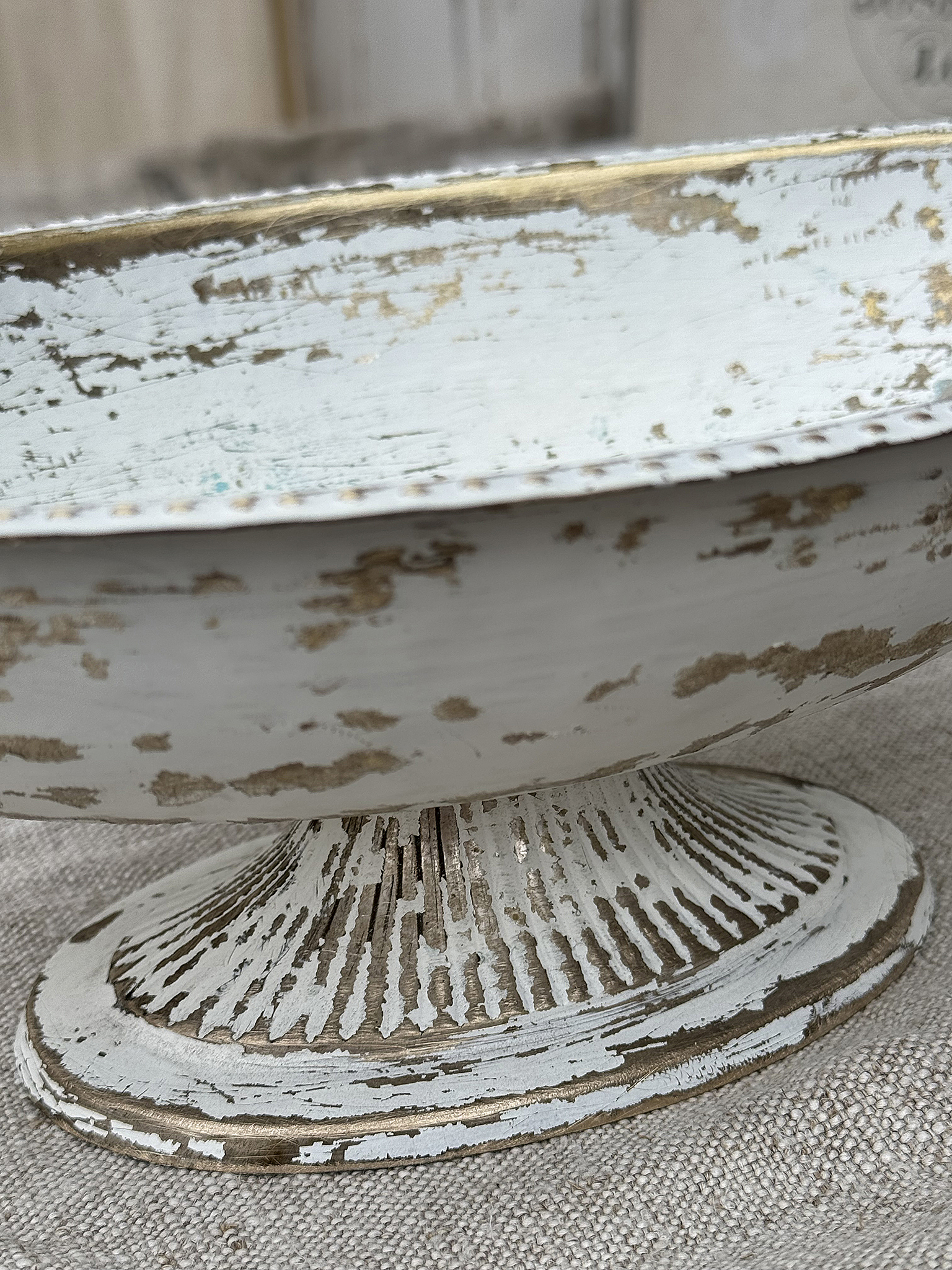 Detailaufnahme eines rustikalen Tellers mit goldenen Rändern auf einem neutralen Hintergrund