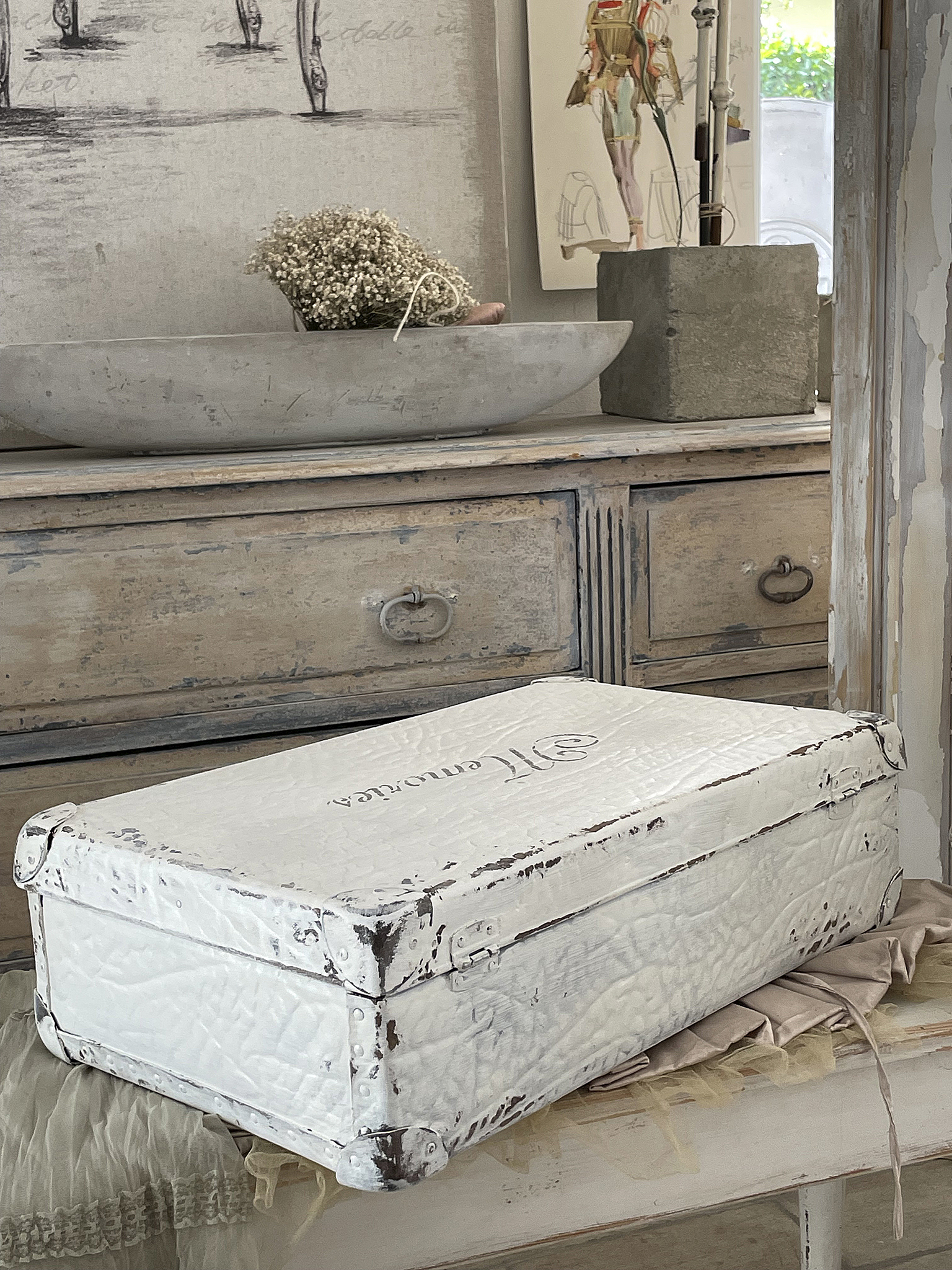 Elegante weiße Aufbewahrungskiste mit vintage Charme Weißer Vintage-Koffer auf einem Holztisch, umgeben von Dekoration