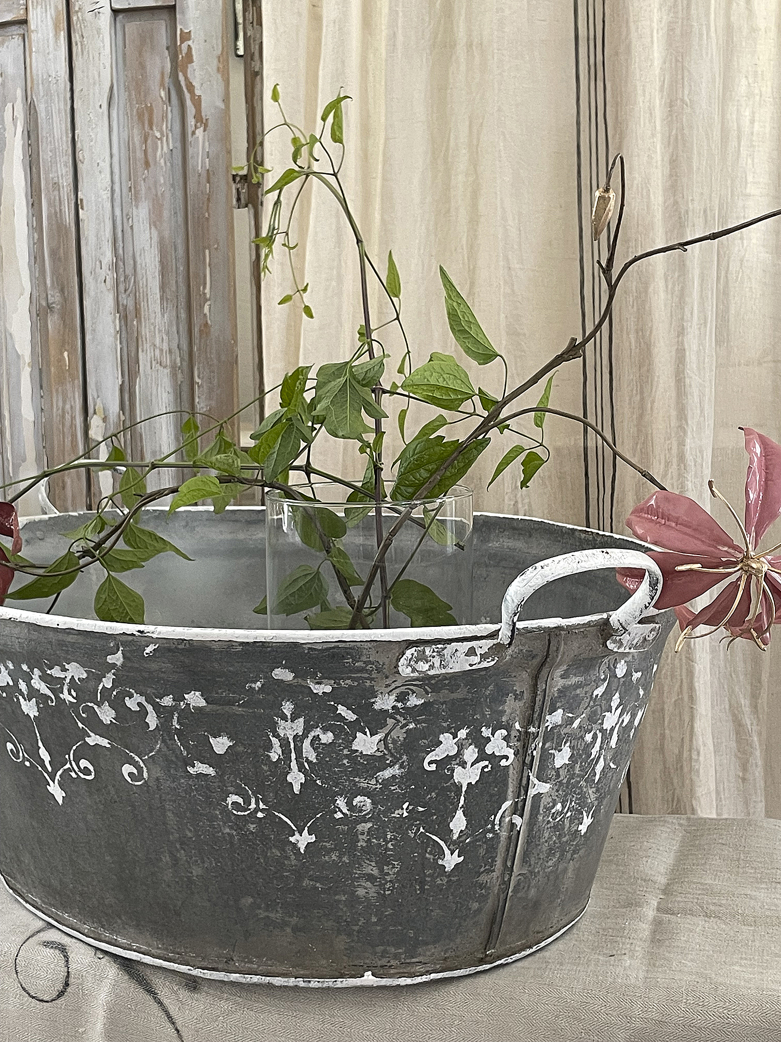 Elegante Zinkwanne mit schönen Pflanzenarrangements Zinkwanne dekoriert mit grünen Pflanzen und dekorativen Blüten
