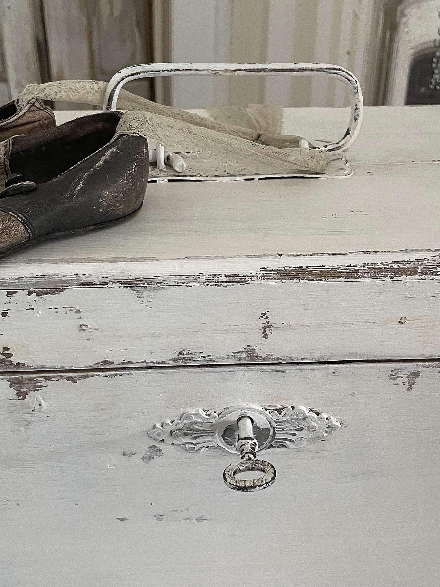 Vintage Schuhe auf einer rustikalen Holzkommode Detailaufnahme von alten Schuhen auf einer abgenutzten Holzoberfläche mit einem Schlüsselloch.