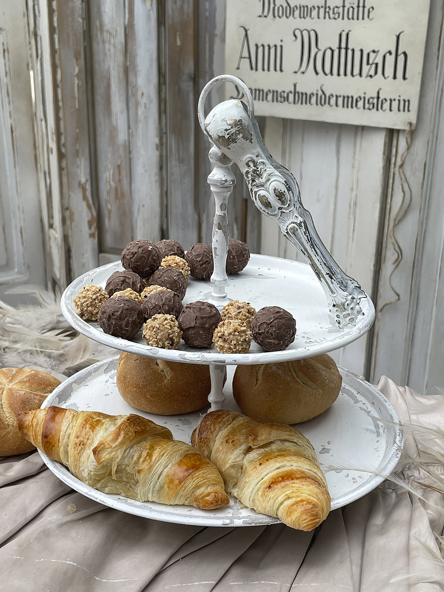 Lustige Nachmittags-Delikatessen auf einem eleganten Etagere Etagere mit verschiedenen Gebäcksorten wie Croissants und süßen Pralinen