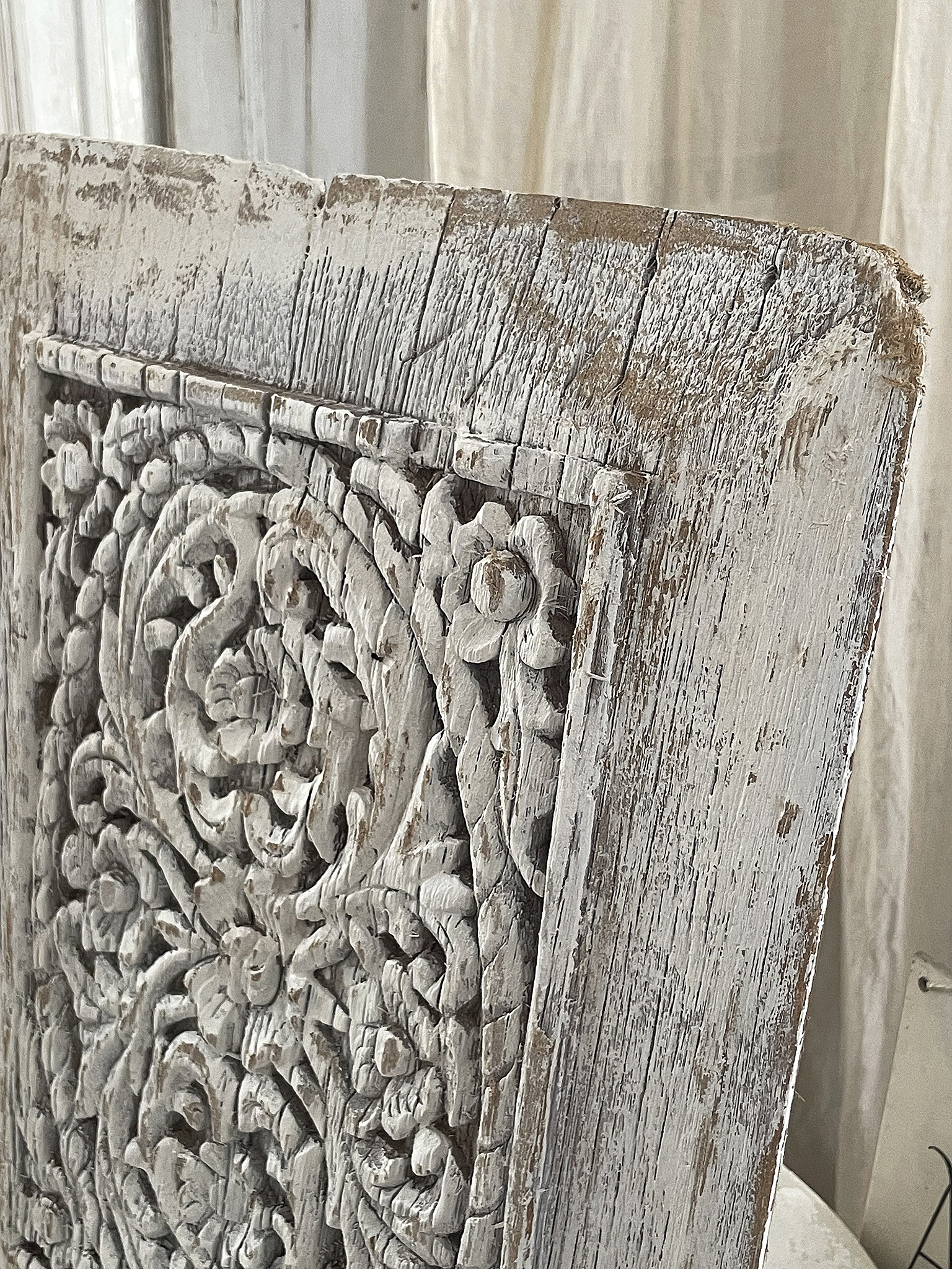Detailaufnahme eines kunstvoll geschnitzten Holzpaneels in Weiß Kunstvoll geschnitztes Holzpaneel mit floralen Motiven in weißer Farbgebung.