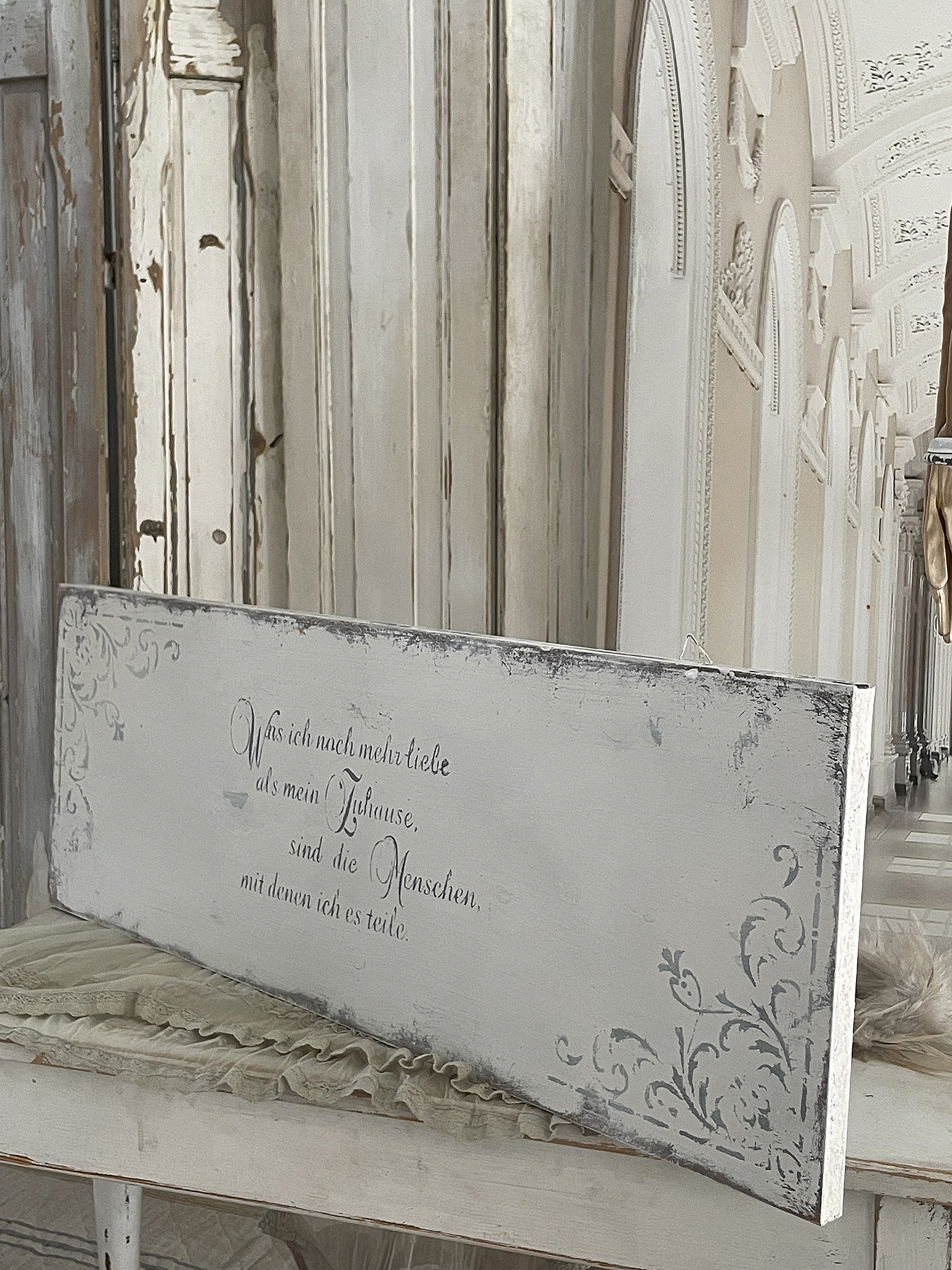 Deko-Element mit liebevollem Spruch über Zuhause und Menschen Dekoratives Schild mit Schriftzug: 'Was ich nach mehr liebe als mein Zuhause, sind die Menschen, mit denen ich es teile.'