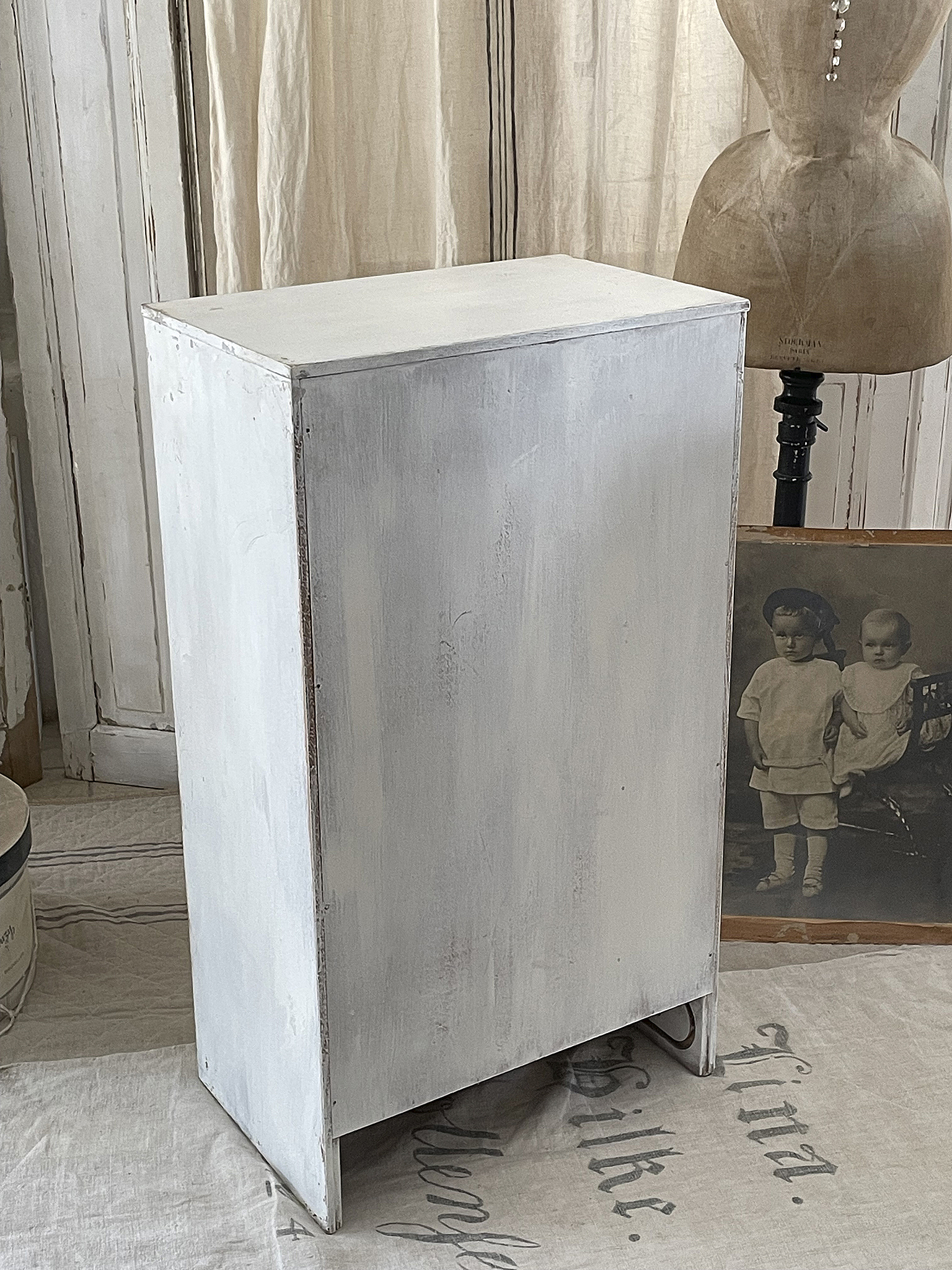 Weißer Holzschrank im skandinavischen Stil vor einem nostalgischen Hintergrund