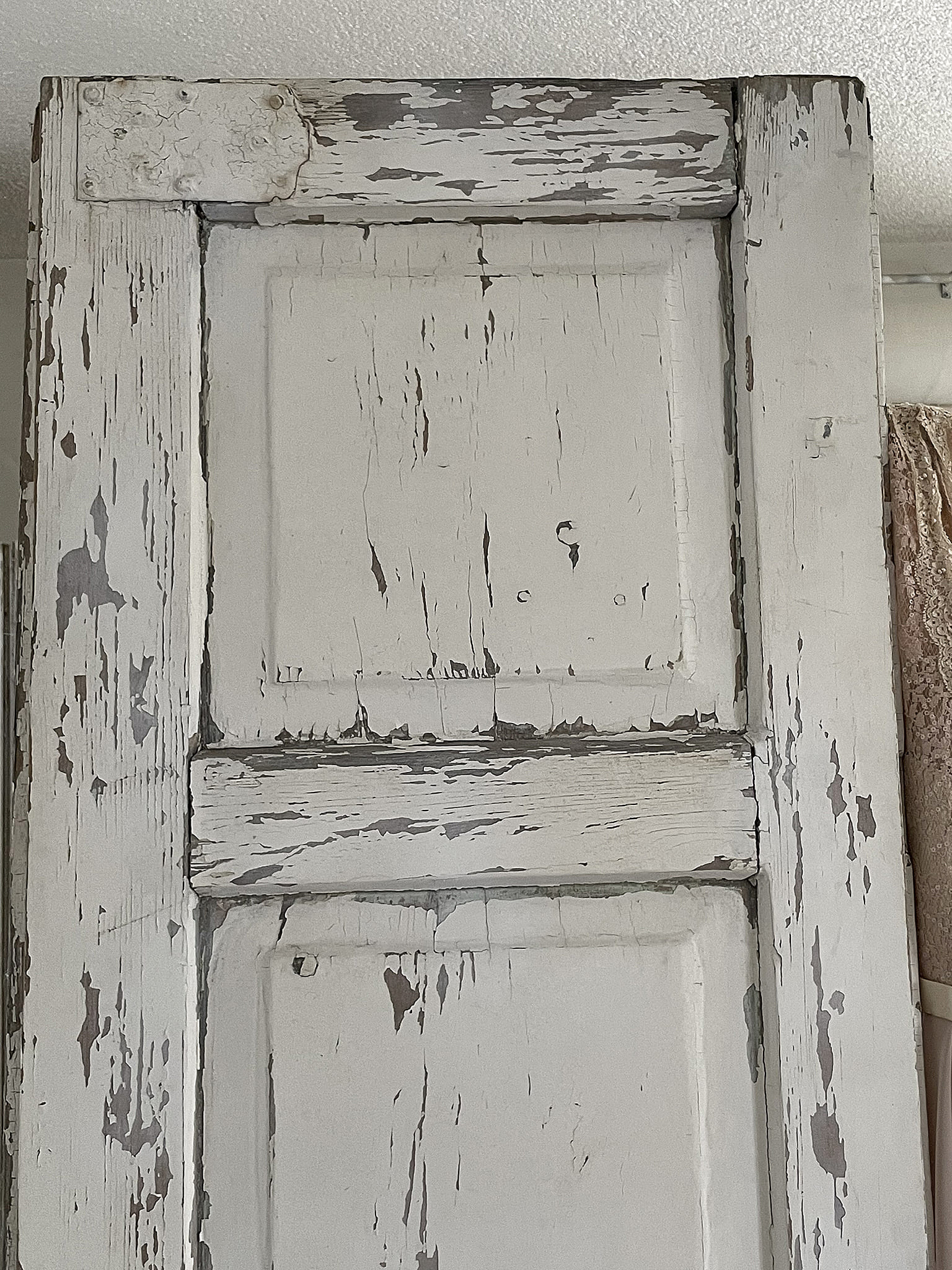 Nahaufnahme einer antiken, shabby-chic Tür mit sichtbarem Farbabrieb und Holzstrukturen
