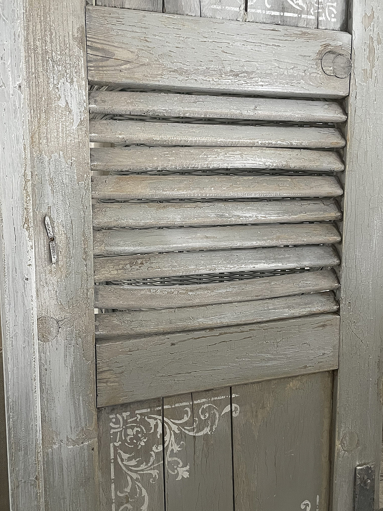 Vintage Holzjalousie in Grau mit Ornamenten Nahaufnahme einer grauen Holzjalousie mit filigranen Verzierungen