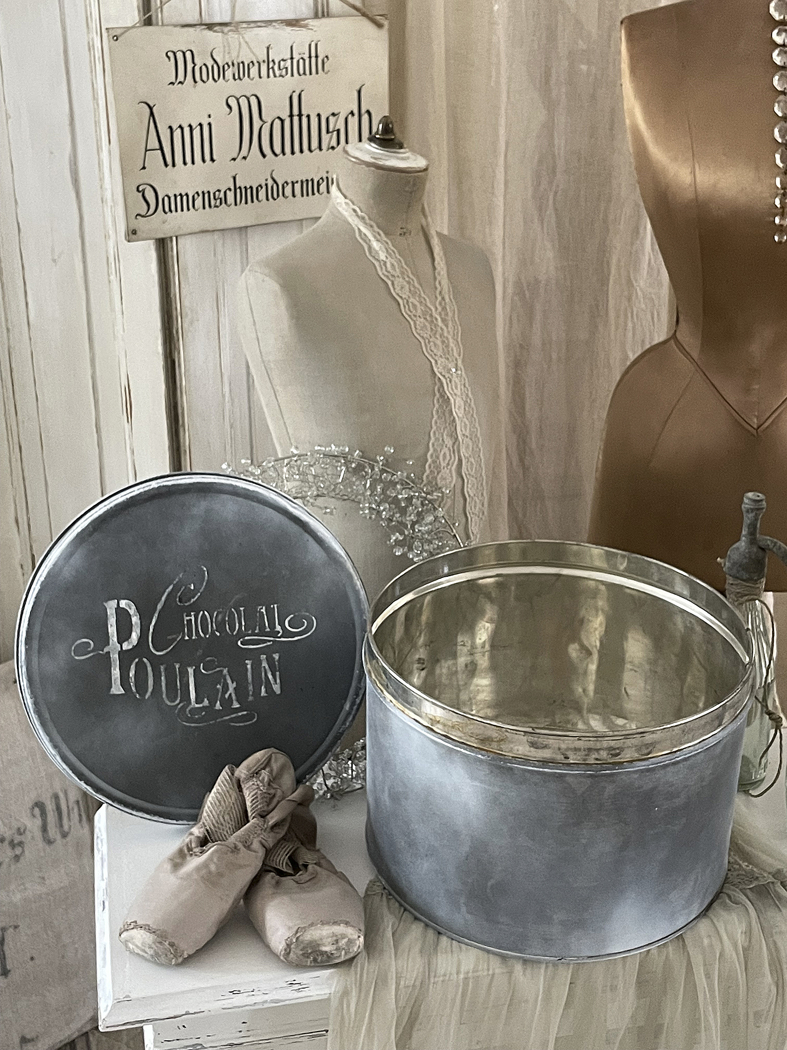 Deko-Objekt: Metallbehälter mit Inschrift Chocolat Poulain und Ballettschläppchen