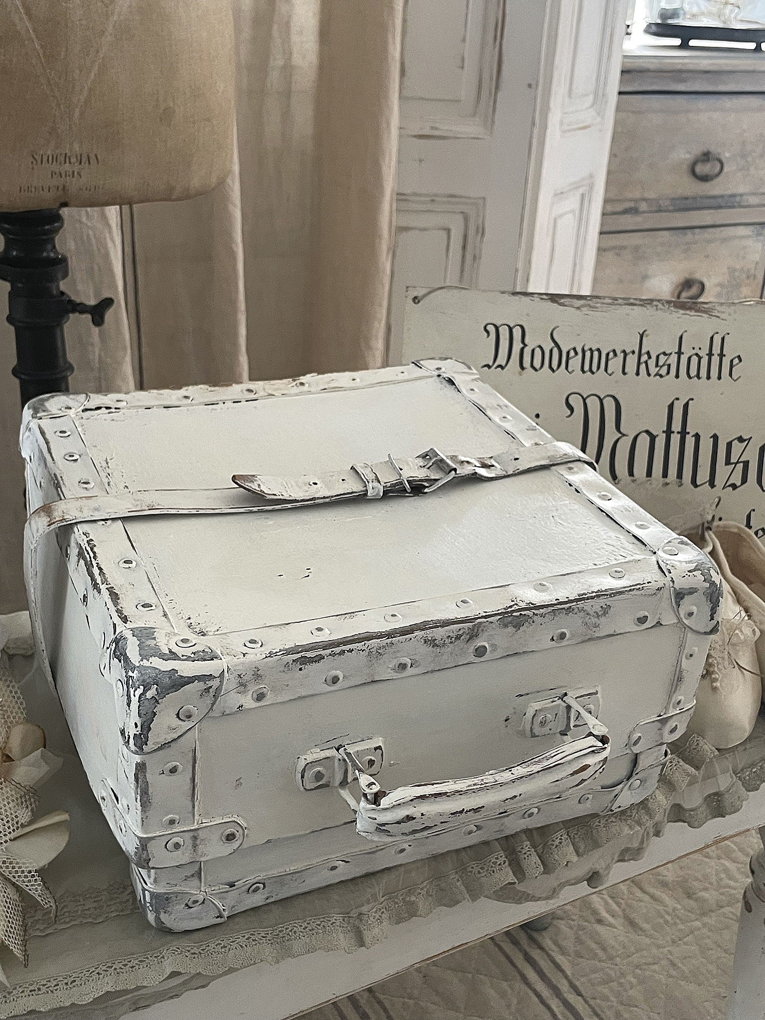 Vintage Koffer in Weiß mit Lederdetails Weißer, vintage Koffer mit abgenutzten Lederdetails und einem nostalgischen Erscheinungsbild.