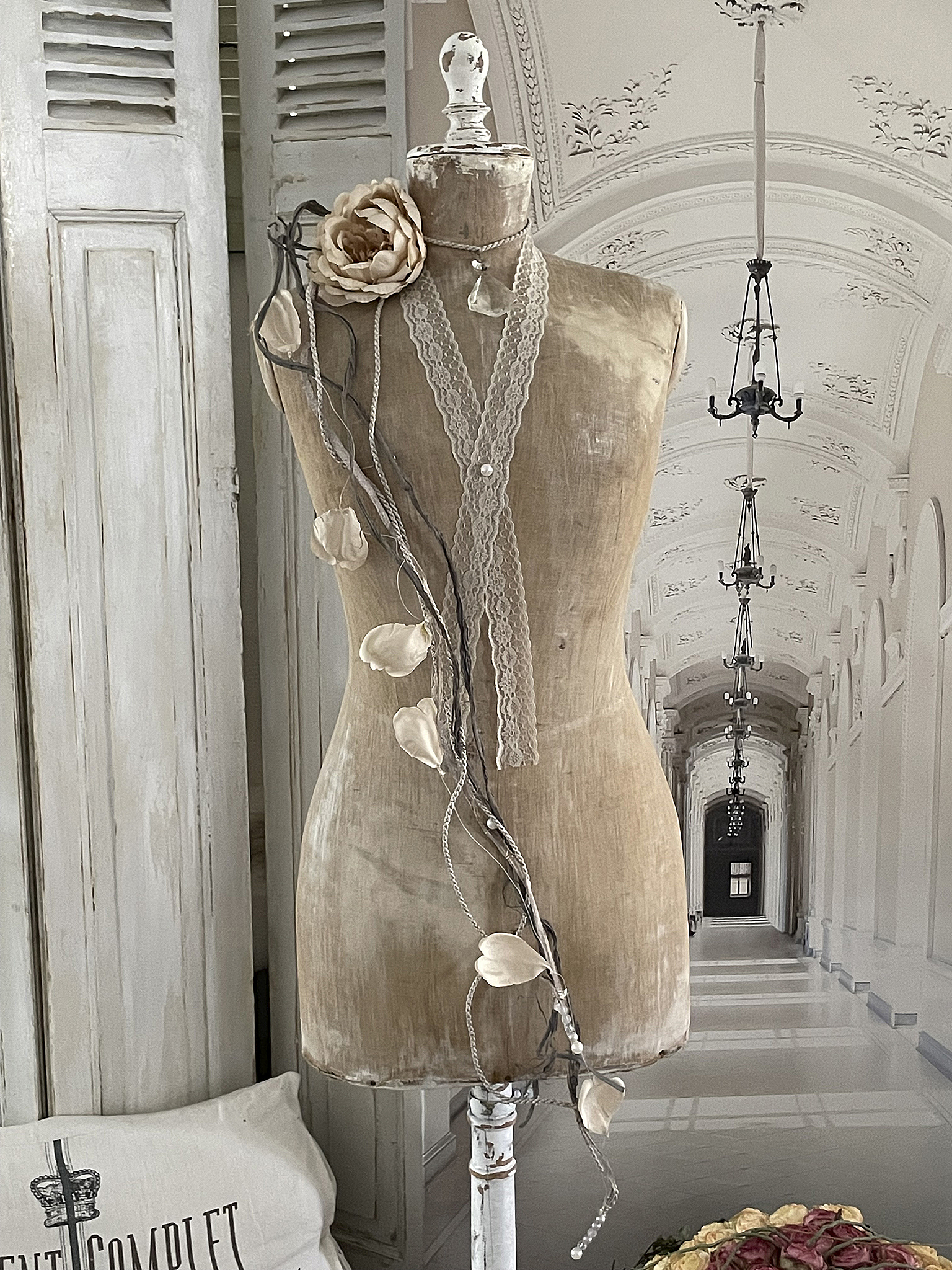 Elegante Schneiderpuppe mit floralen Dekorationen in nostalgischer Umgebung Schneiderpuppe mit einer Blume und einer Schnur, umgeben von einem eleganten Innenraum
