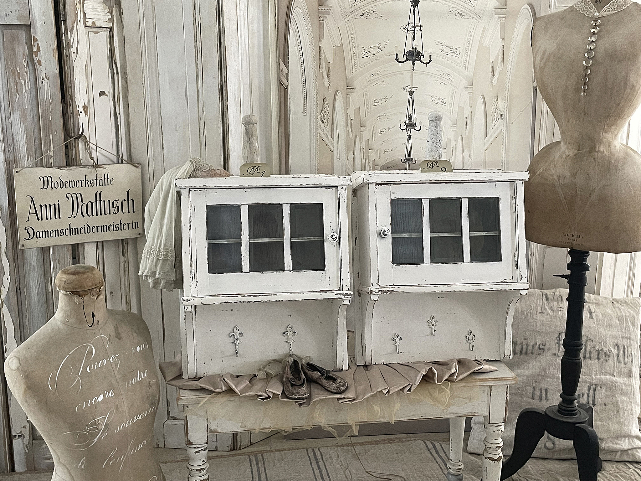 Klassisches Vintage-Möbelstück in Schneiderwerkstatt Blick auf eine stilvolle Schneiderwerkstatt mit weißen Möbeln und einem vintage Mannequin.