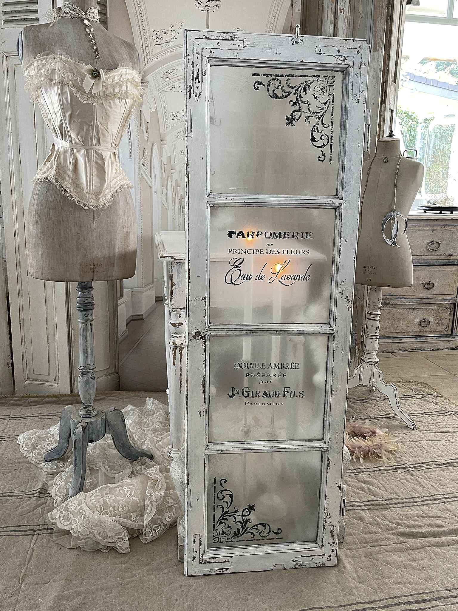 Elegante Vintage-Deko mit Parfüm-Glastür und Korsett-Ständer Dekoratives Element mit Parfüm-Glastür und einem stilvollen Korsett auf einem Ständer