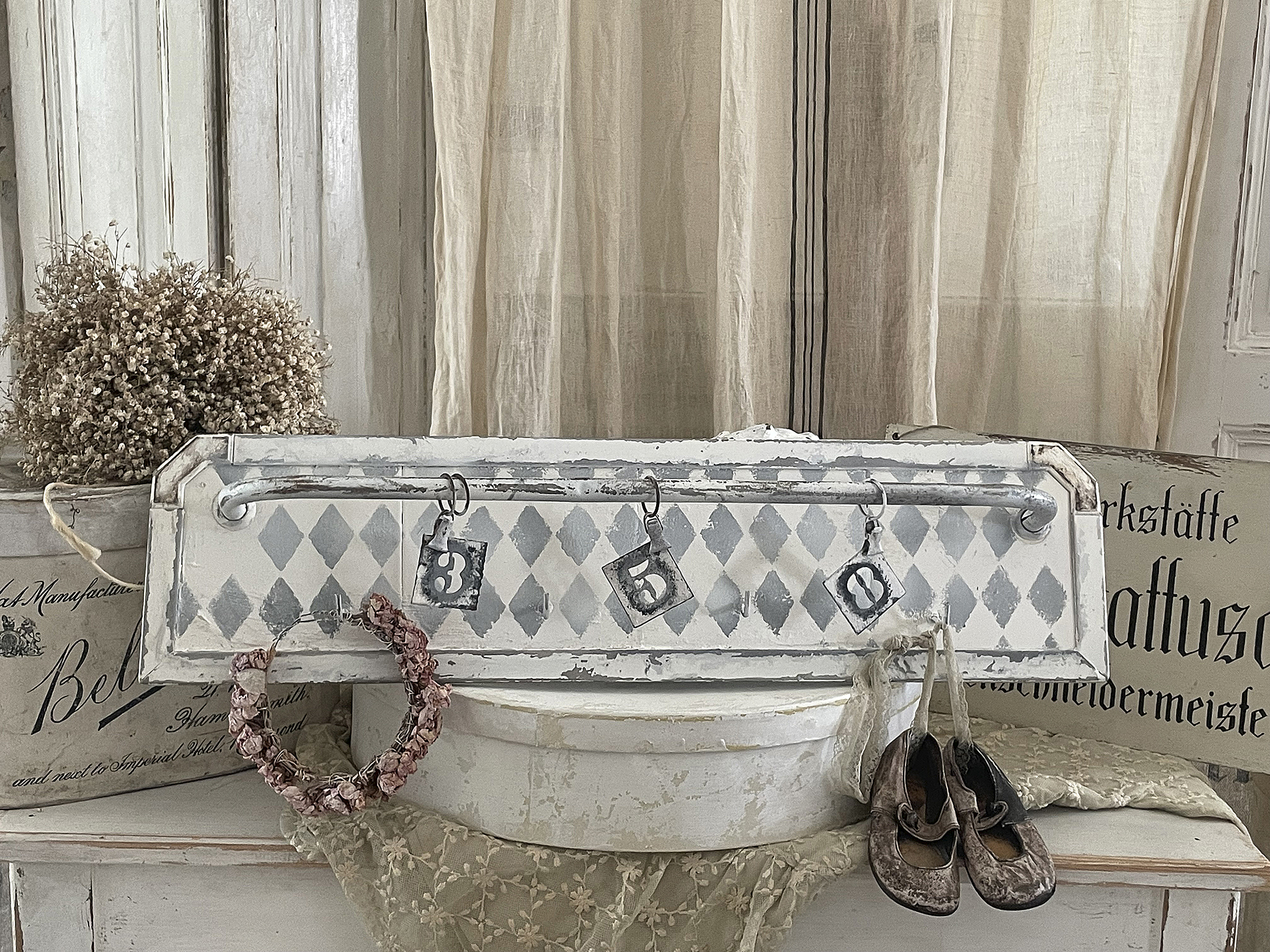 Dekorativer Wandhaken mit vintage Details und Schuhen Wandhaken im Vintage-Stil mit Rosenkranz und alten Schuhen