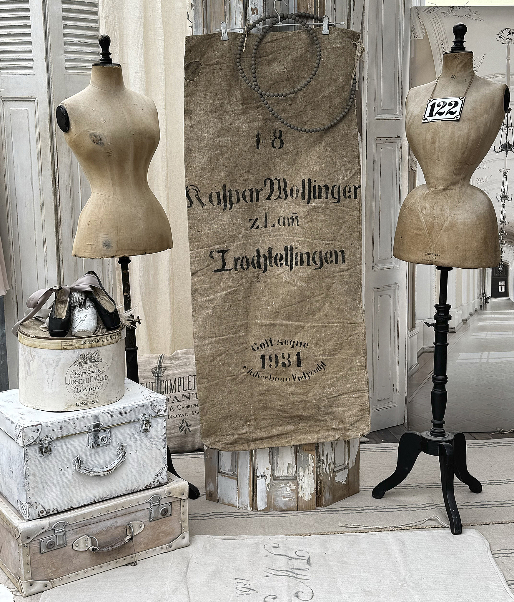 Vintage Schneiderpuppen und Dekorative Koffer im Shabby-Chic-Stil Schneiderpuppen und alte Koffer in einem stilvollen, leicht rustikalen Raum