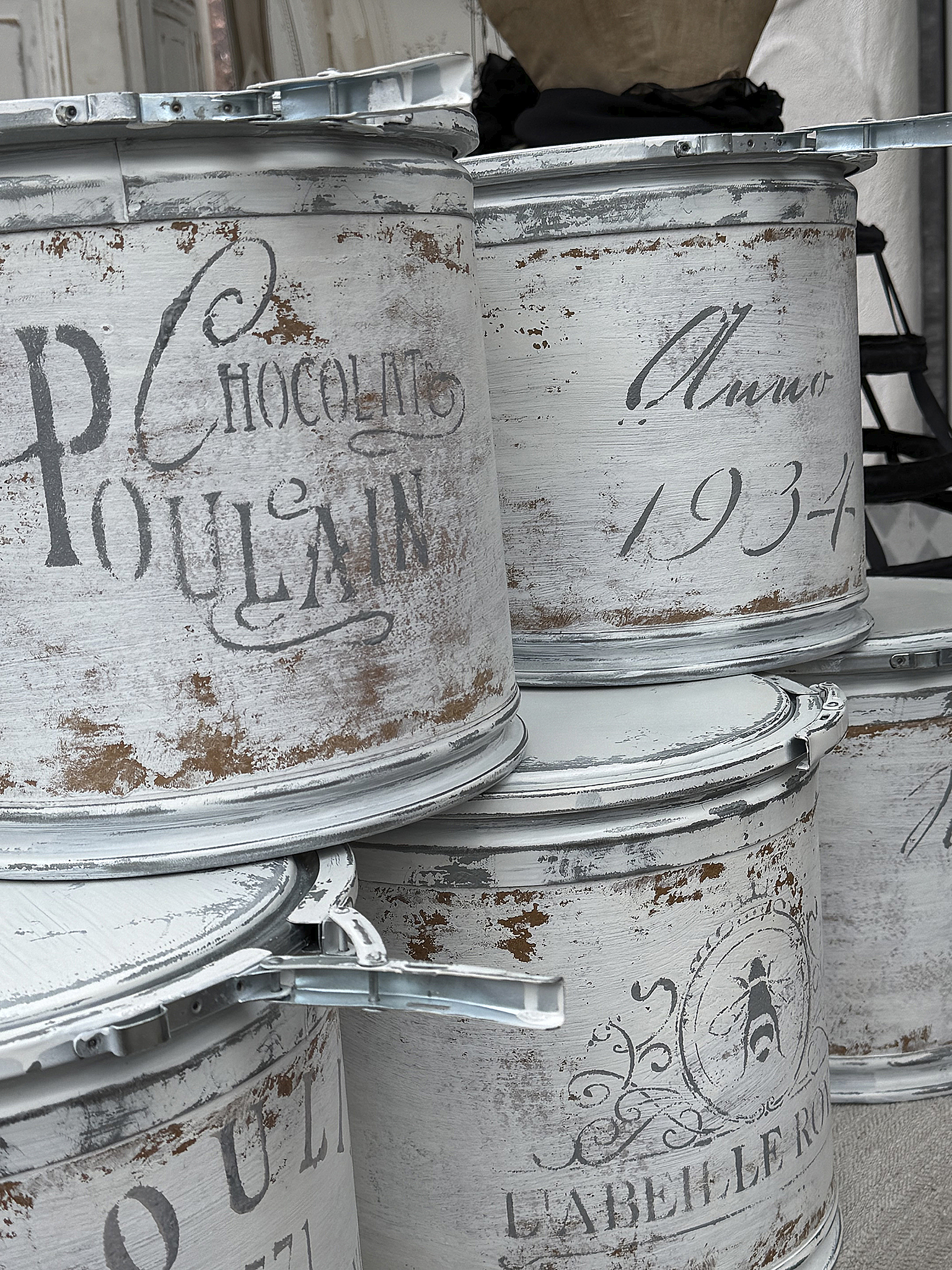 Antike Weißblechdosen mit nostalgischem Design Stapel von rustikalen Weißblechdosen mit dekorativen Schriftzügen und verwaschenem Look