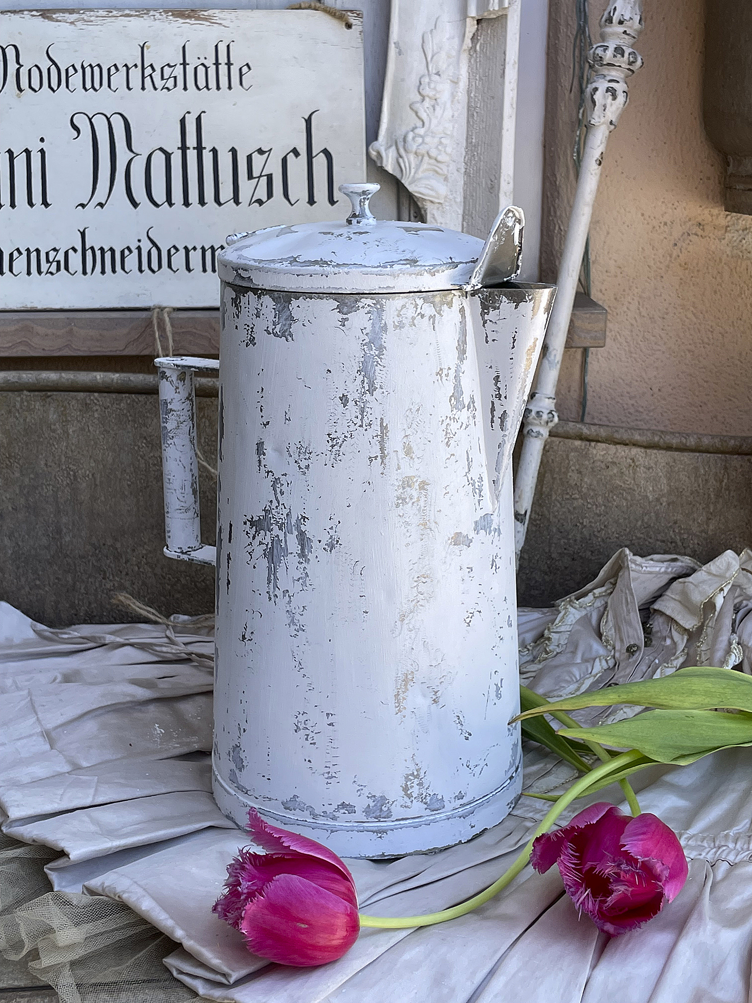 Vintage Weißer Kaffeekanne mit Tulpen im Hintergrund Dekorative weiße Kaffeekanne mit Tulpen auf einem Tisch