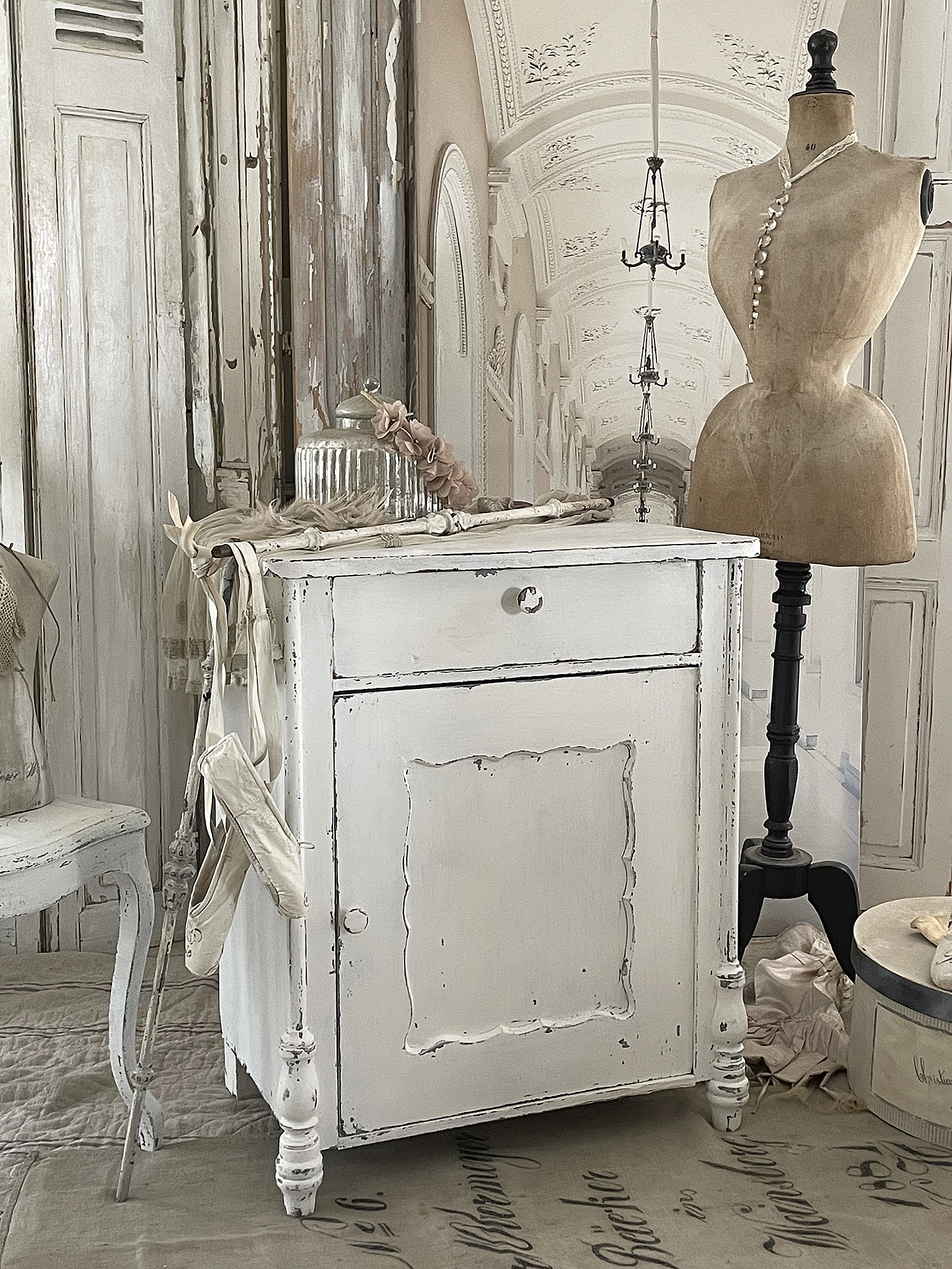 Eleganter weisser Vintage-Schrank mit dekorativen Details Vintage-Schrank in weisser Farbe mit nostalgischem Flair und stilvollen Accessoires