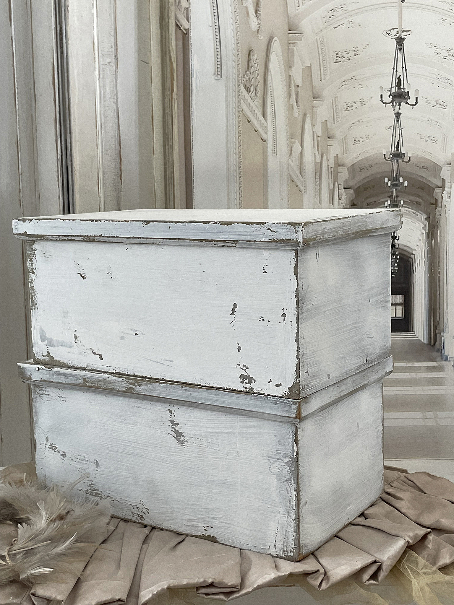 Dekorative Vintage-Holzkiste im shabby Chic-Stil Weiße, antik aussehende Holzkiste auf einem beigen Tuch in einem eleganten Raum