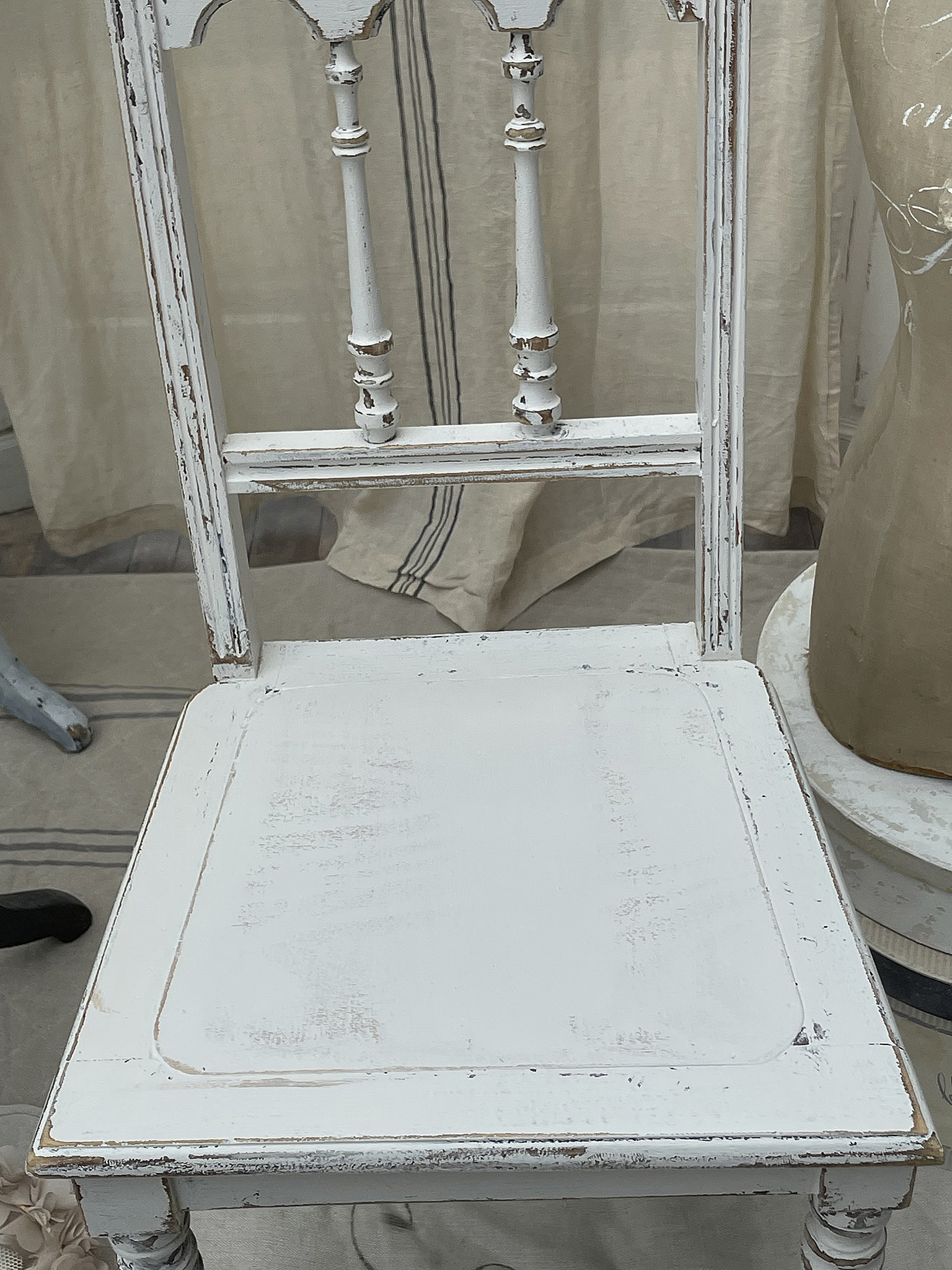 Antiker, weißer Stuhl mit nostalgischem Charme Detailaufnahme eines antiken, gebrauchten weißen Stuhls mit sichtbaren Gebrauchsspuren.