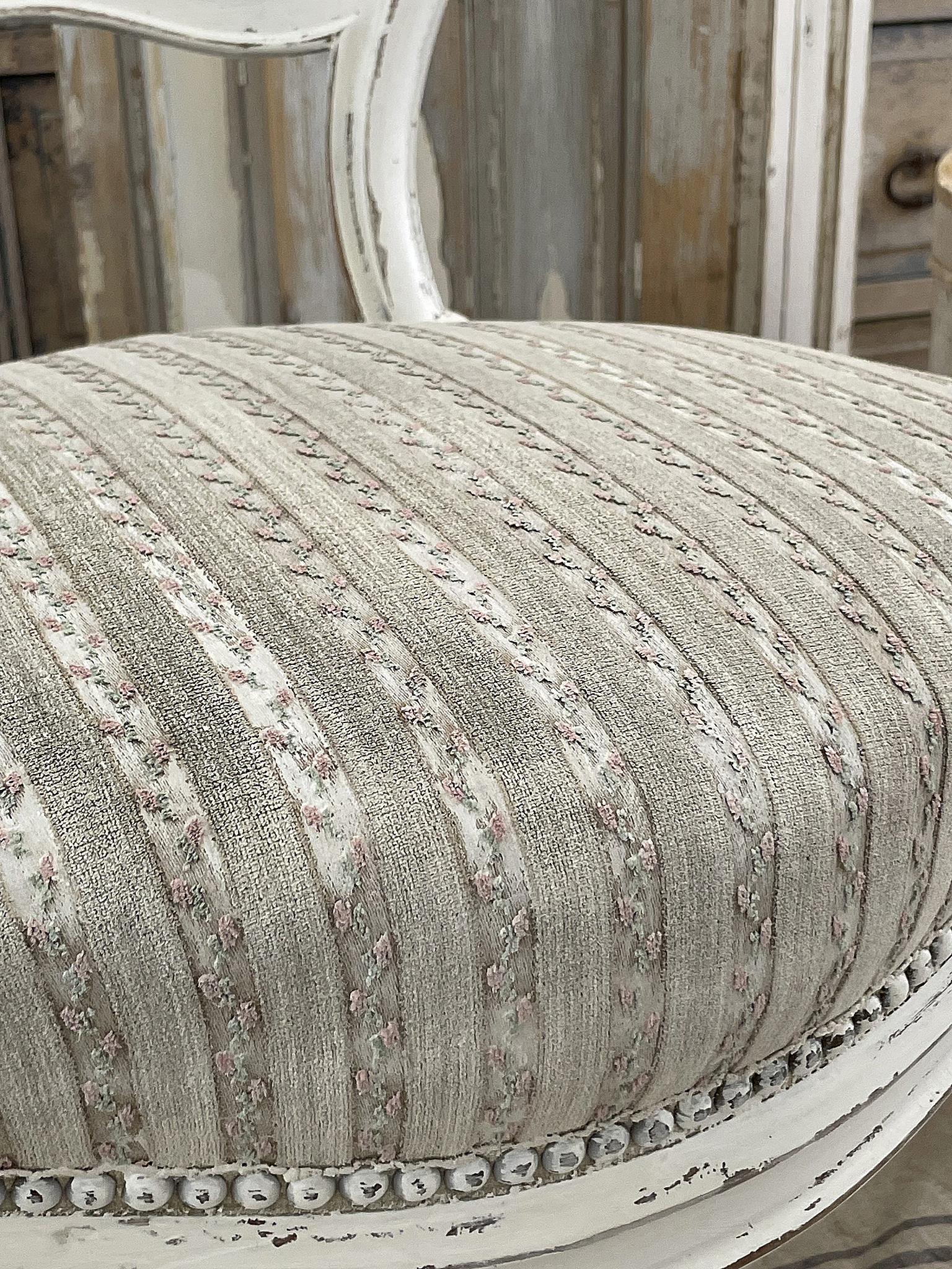 Eleganter Polstersitz mit ansprechendem Blumenmuster Nahaufnahme eines stilvollen Polstersitzes mit gestreiftem Muster und feinem Blumenmotiv