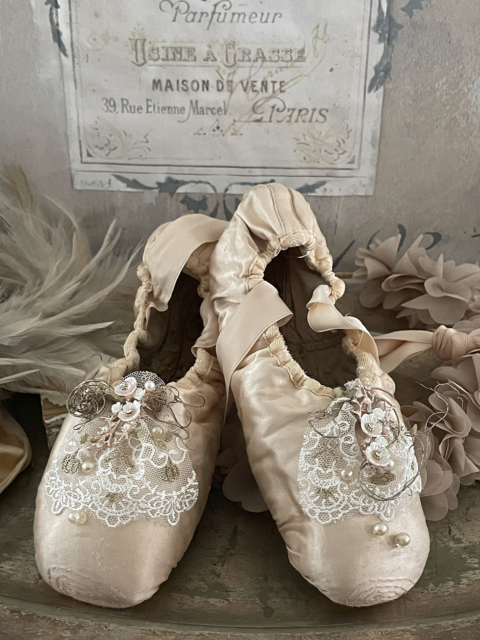 Elegante Ballettschuhe mit Verzierung Zwei stilvolle Ballettschuhe in Rosa mit dekorativen Details auf einem rustikalen Untergrund