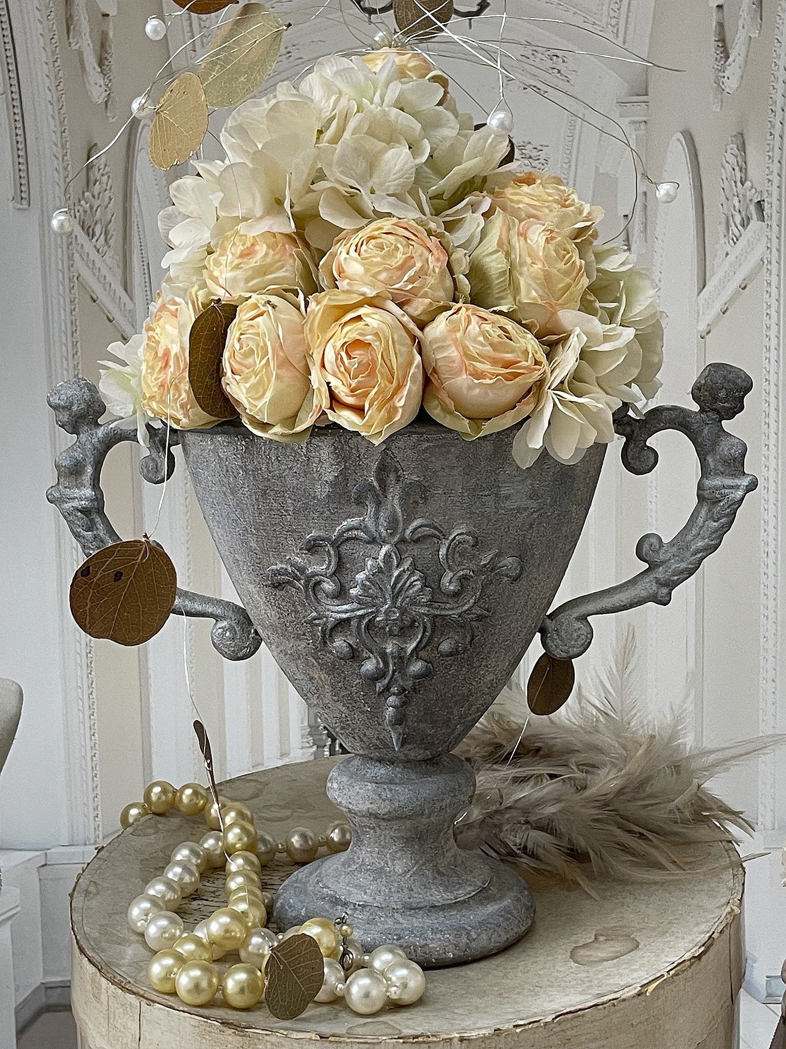 Elegante Blumenvase mit Rosen und dekorativen Elementen Dekorative Blumenvase aus Metall mit rosafarbenen Rosen und Perlenschmuck