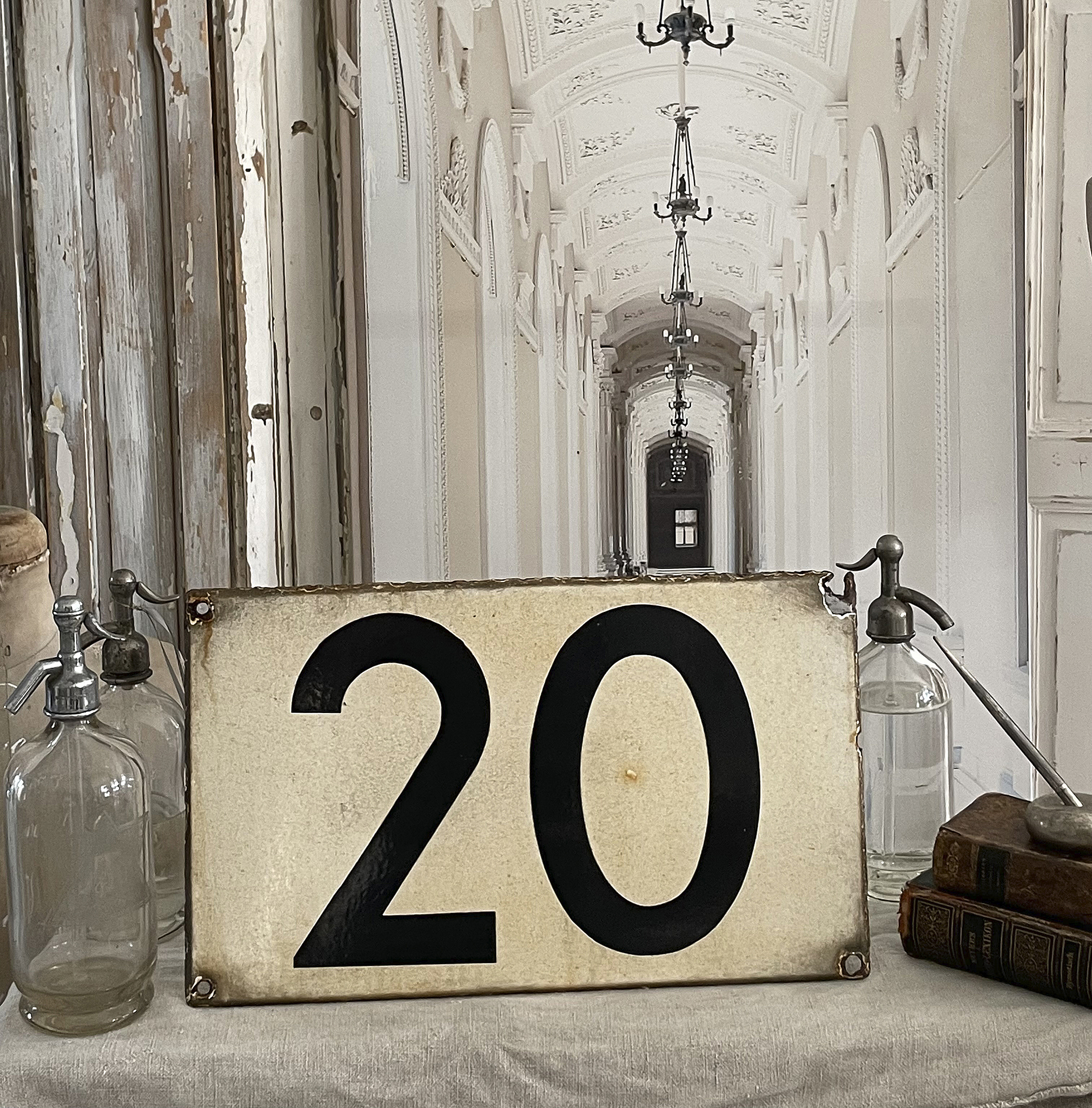 Rustikales Nummernschild mit der Zahl 20 auf einem Tisch, umgeben von Vintage-Objekten.