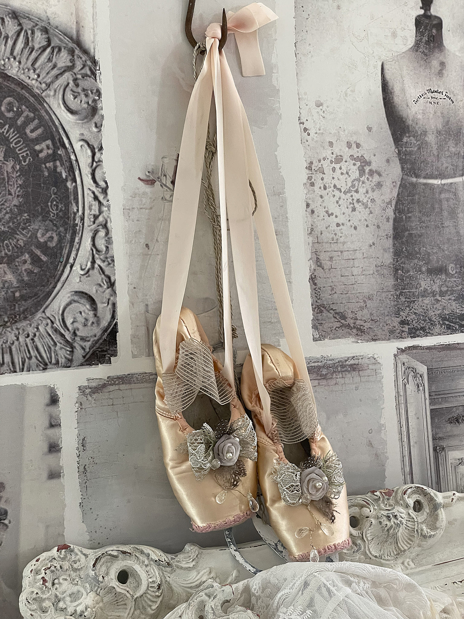 Ballettschuhe in zartem Rosa mit dekorativen Röschen und Schleifen, aufgehängt.