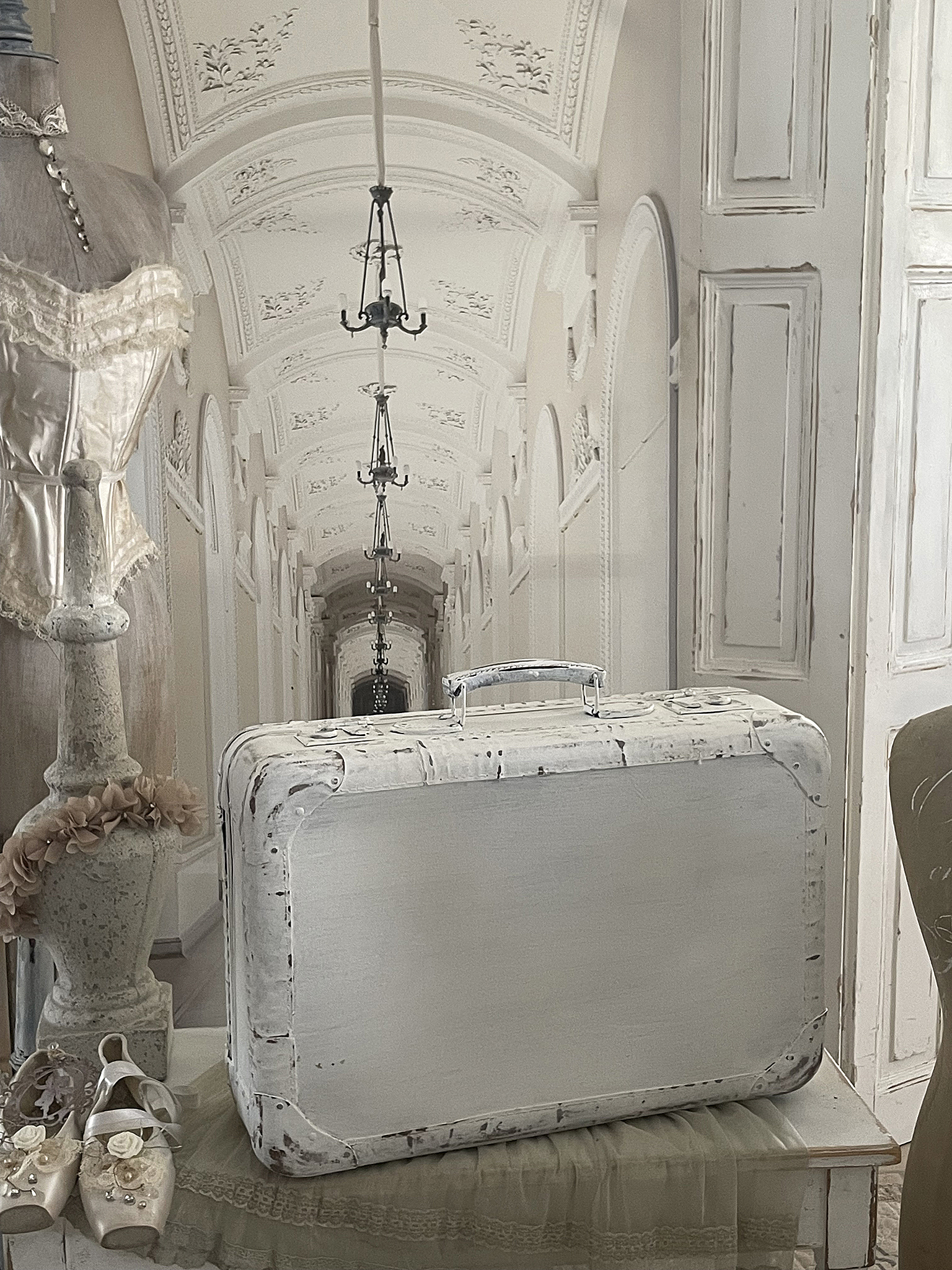 Eleganter Koffer im Vintage-Stil vor festlichem Hintergrund Weißer Koffer mit vintage Flair in einem eleganten Raum