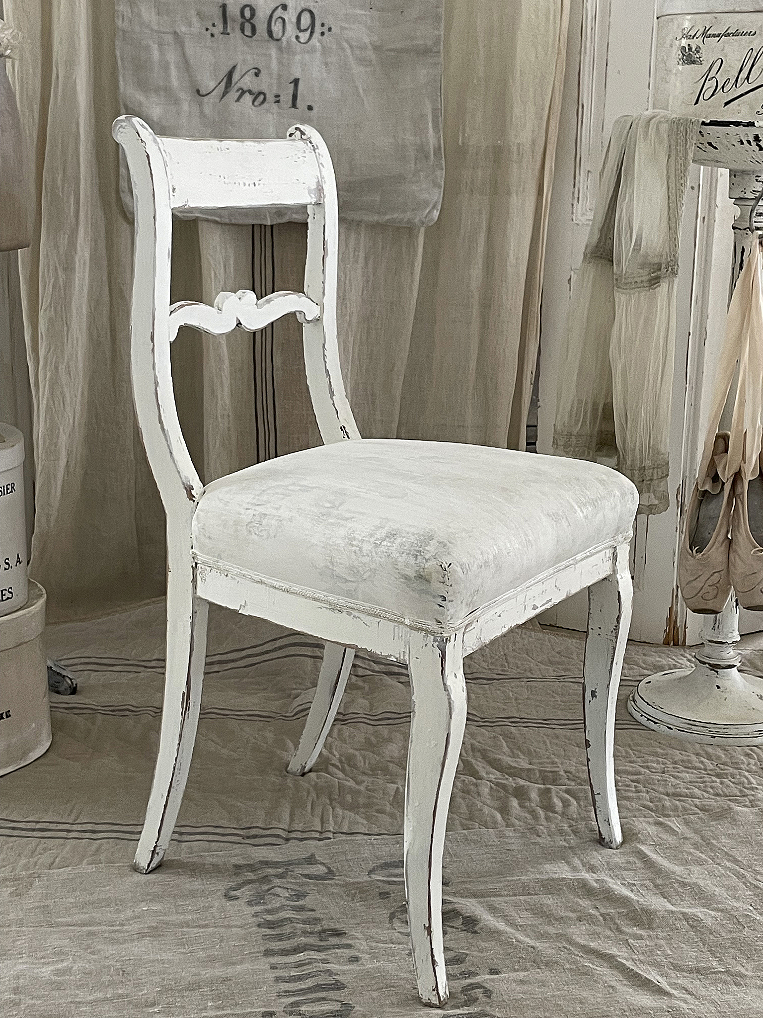 Antiker weißer Stuhl mit nostalgischem Charme Antiker Stuhl mit weißer Farbe und gepolsterter Sitzfläche
